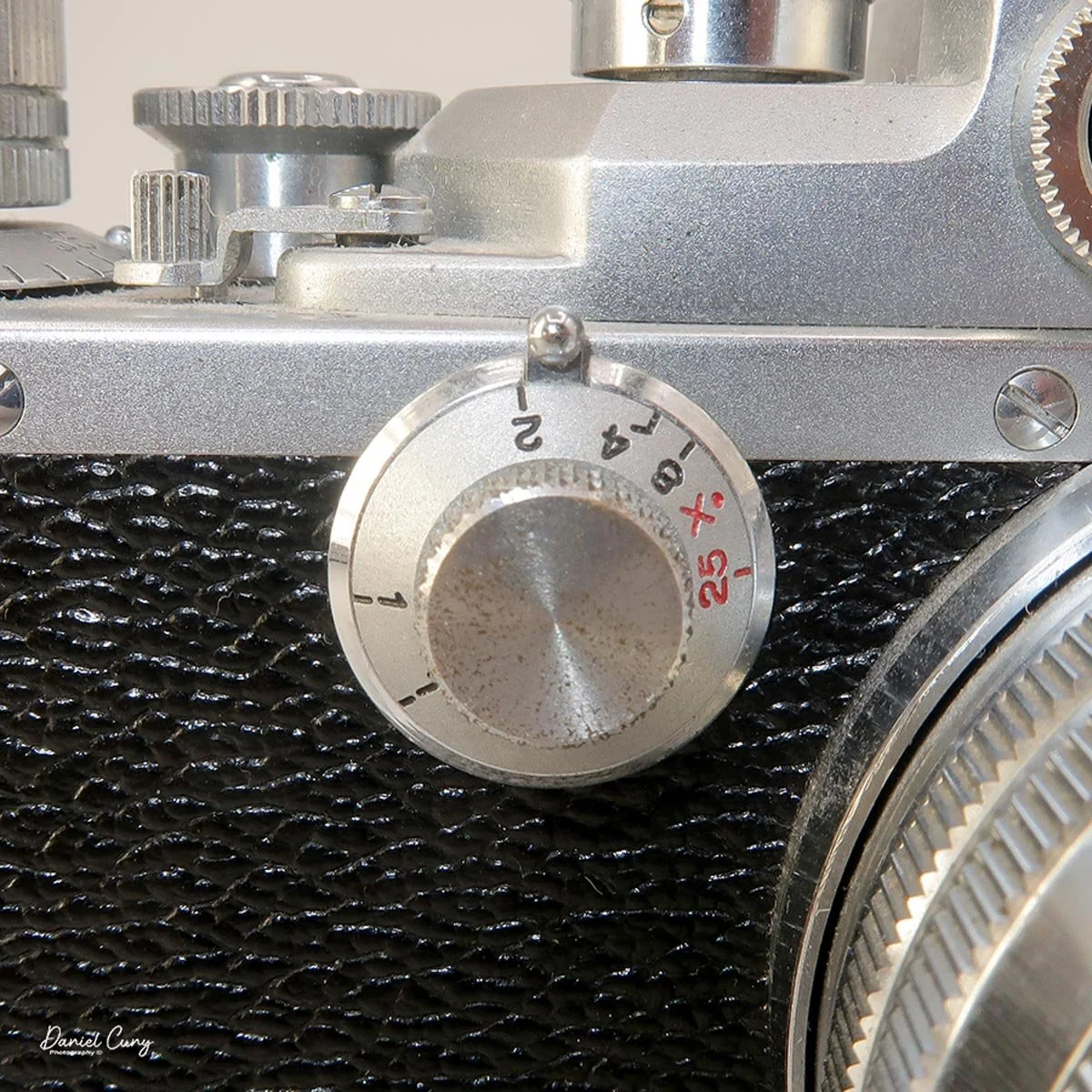 Low end shutter speed dial with locking pin on top.