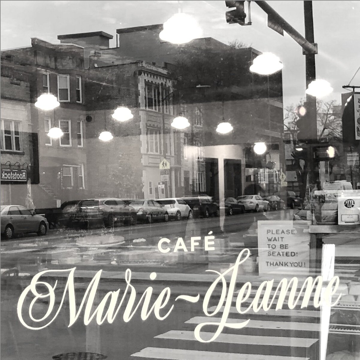 Window of Café Marie-Jeanne at 1001 N. California Ave.  with Rootstock Wine &amp; Beer Bar in the reflection