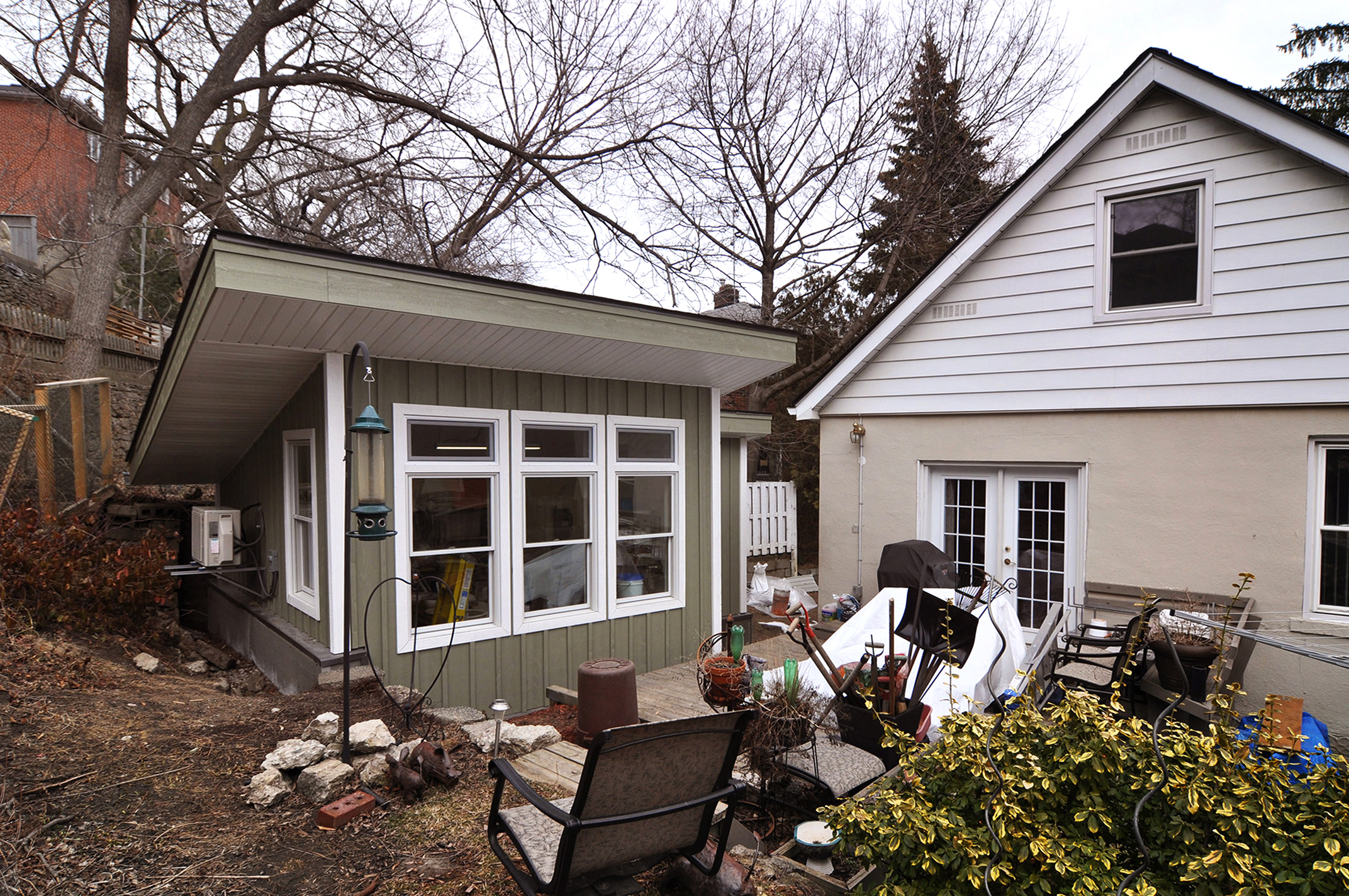 Pottery Studio Replacing an Old Garage with a Backyard Pottery Studio When our client initially purchased this home, they knew they wanted to use the existing, old and worn, detached garage as a studio. The plan was then to rejuvenate the space into what would become a pottery studio. Working with the city and within the constraints of the small site we needed to change the simple rectangular shape of the existing garage to an L-shaped space. The resultant effect is one which greatly improved the quality of the room as one entered the space before turning the corner into the bright and expansive workspace, feeling as if the studio was tucked into the rising landscape of the backyard. The south facing windows allow the artist to work in this space year-round; being warmed by the sun in the winter but shaded at the height of the summer. When additional heating is required, the efficient mini-split heat pump will bring the studio up to a comfortable temperature and the LED lighting keeps the workspace bright whenever needed. The sink, recycled from a restaurant, fits nicely into the side of the workshop yet is deep enough to clean up after any project. With the kiln freshly delivered, we eagerly await the new pieces to come from this inspiring space.