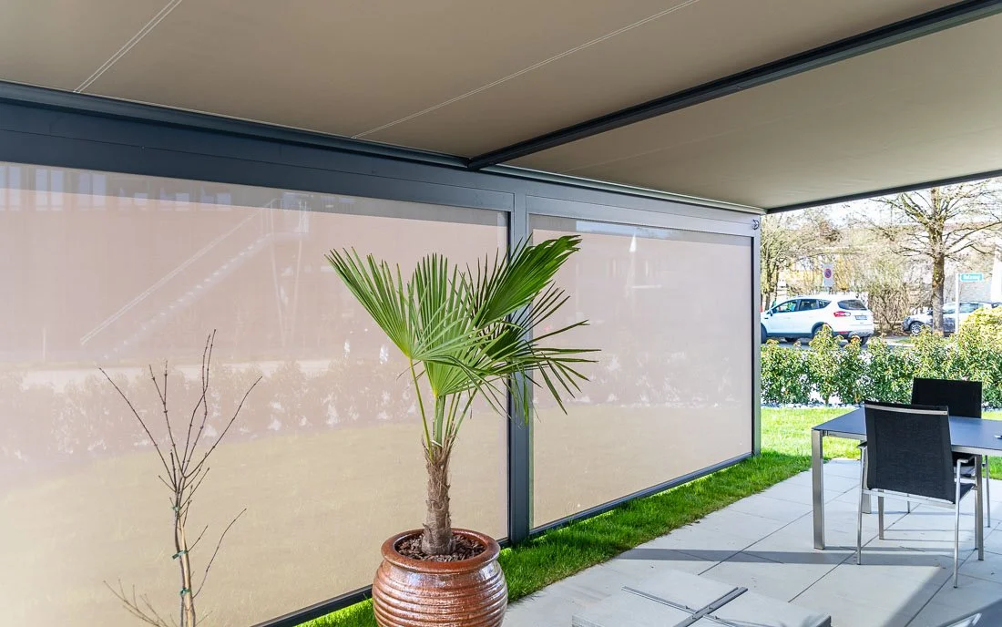 Sitzplatz unter einer Terrassenüberdachung mit heruntergefahrenen Markisen