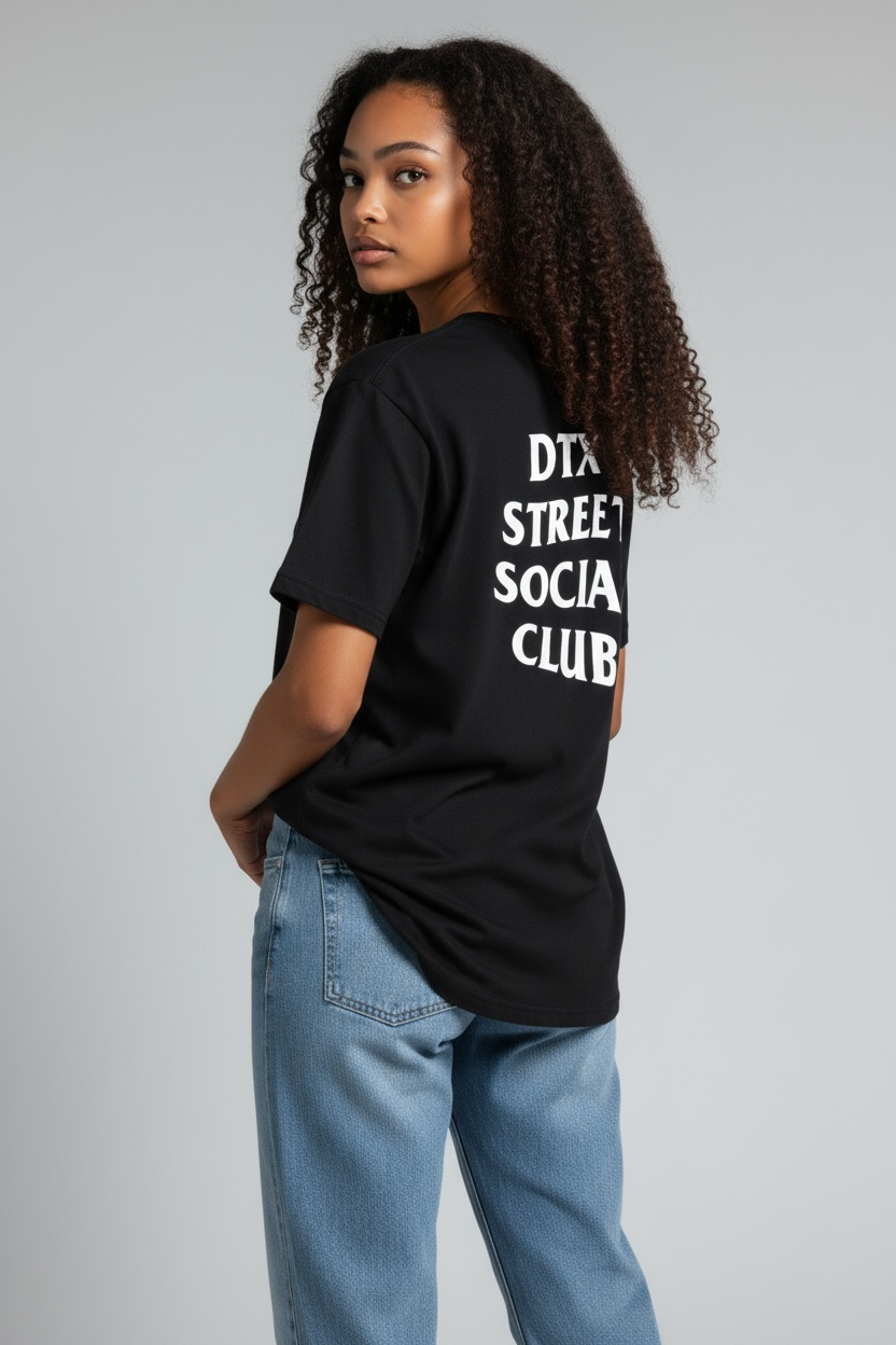 Female model Kendall wearing DTXSTREET ORIGINALS Social Club Tee in black, back view highlighting ‘DTX Street Social Club’ graphic, lifestyle streetwear brand from Dallas Texas