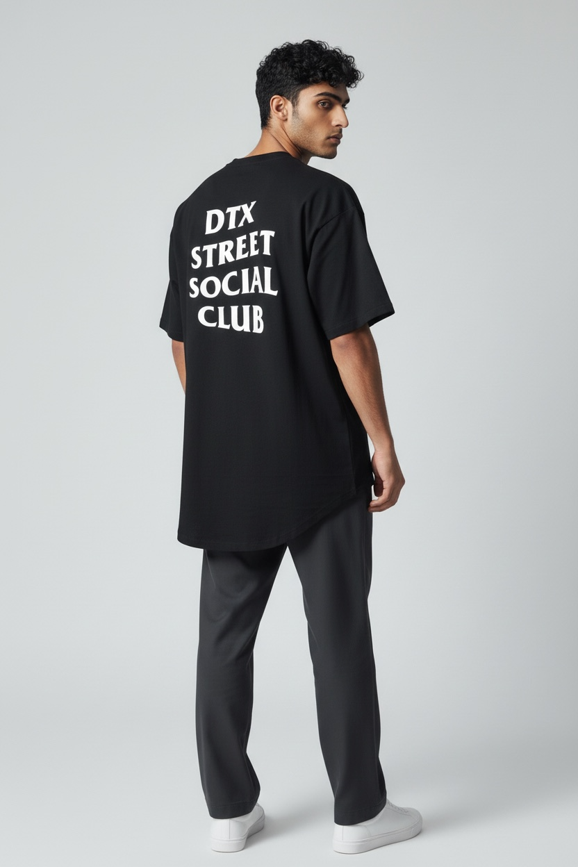 Male model Sam wearing DTXSTREET ORIGINALS Social Club Tee in black, back view showcasing bold ‘DTX Street Social Club’ typography, modern Dallas-based streetwear apparel