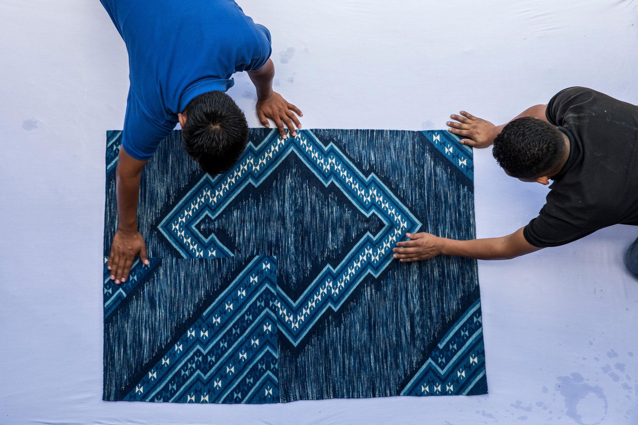 Porfirio Gutiérrez examines a rug colored with natural dye.CreditAdriana Zehbrauskas for The New York Times