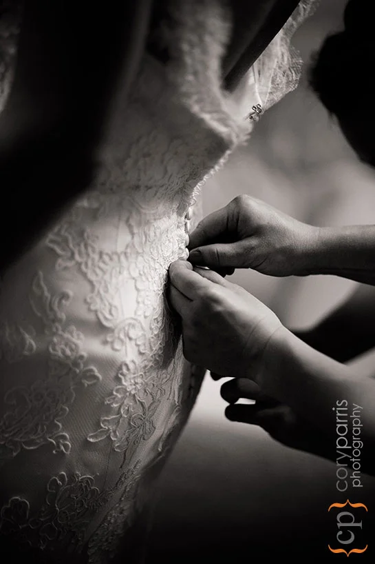 Back of the wedding dress as it is getting buttoned up.