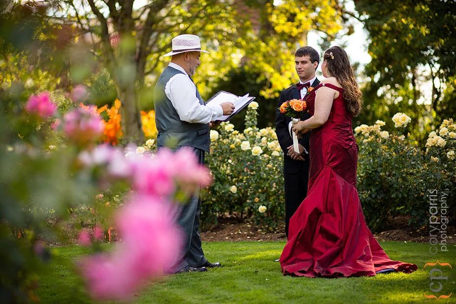 bride and groom getting married in the woodland park rose garden