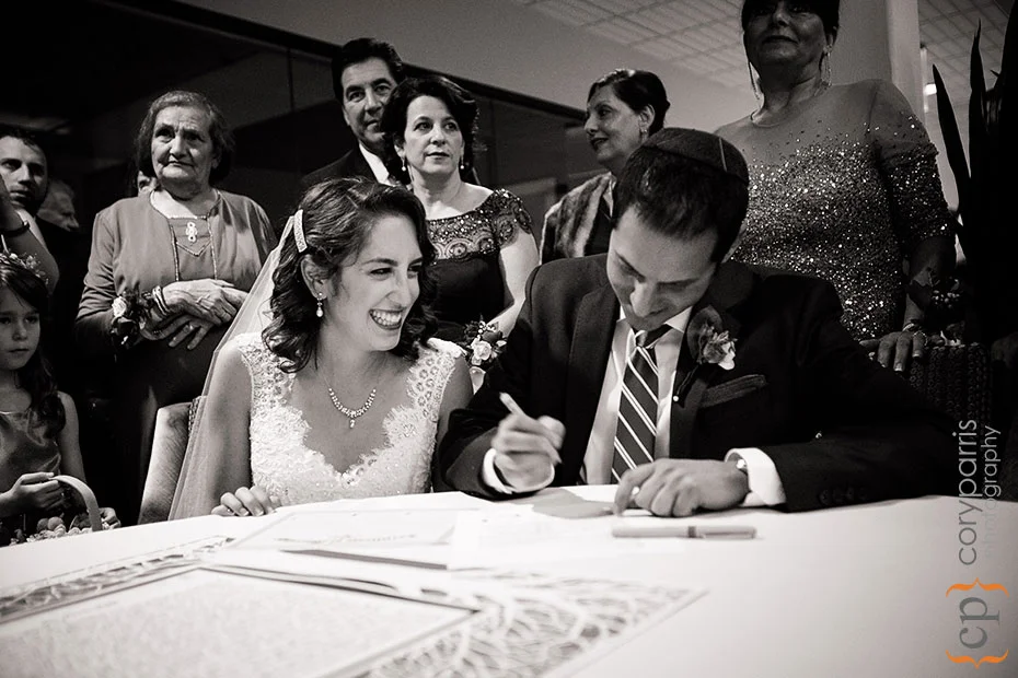 bride and groom signing the Ketubah