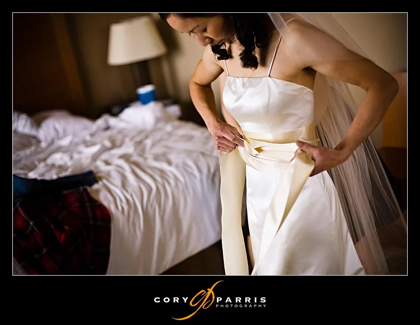 Bride fixing sash on her dress
