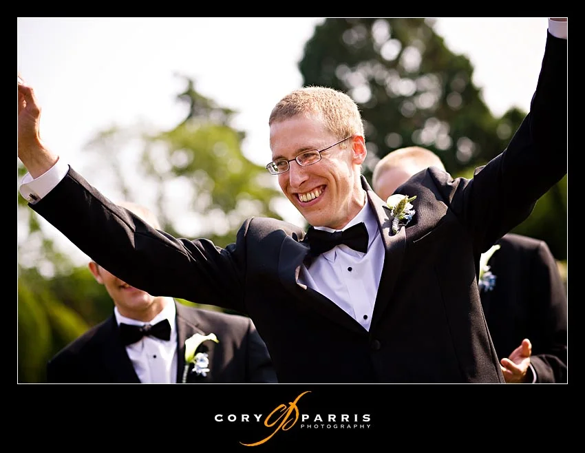 Groom throwing his arms up in celebration after his wedding at the woodland park rose garden in seattle washington as photographed by seattle wedding photographer Cory Parris