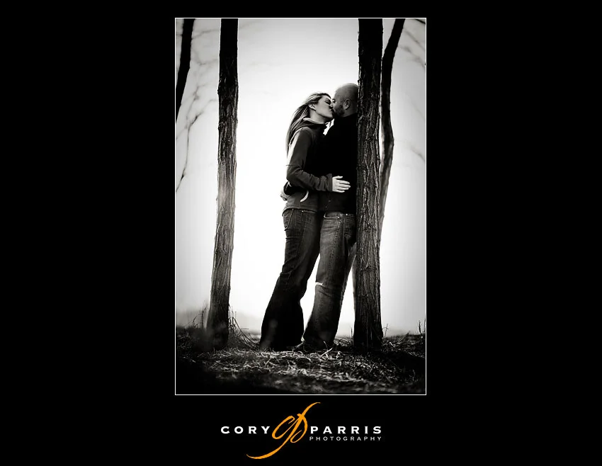 couple kissing by a winter tree