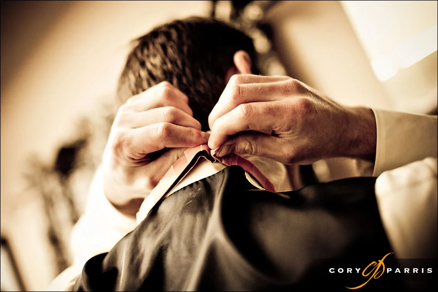 detail of groom putting on his tie by seattle wedding photojournalist cory parris