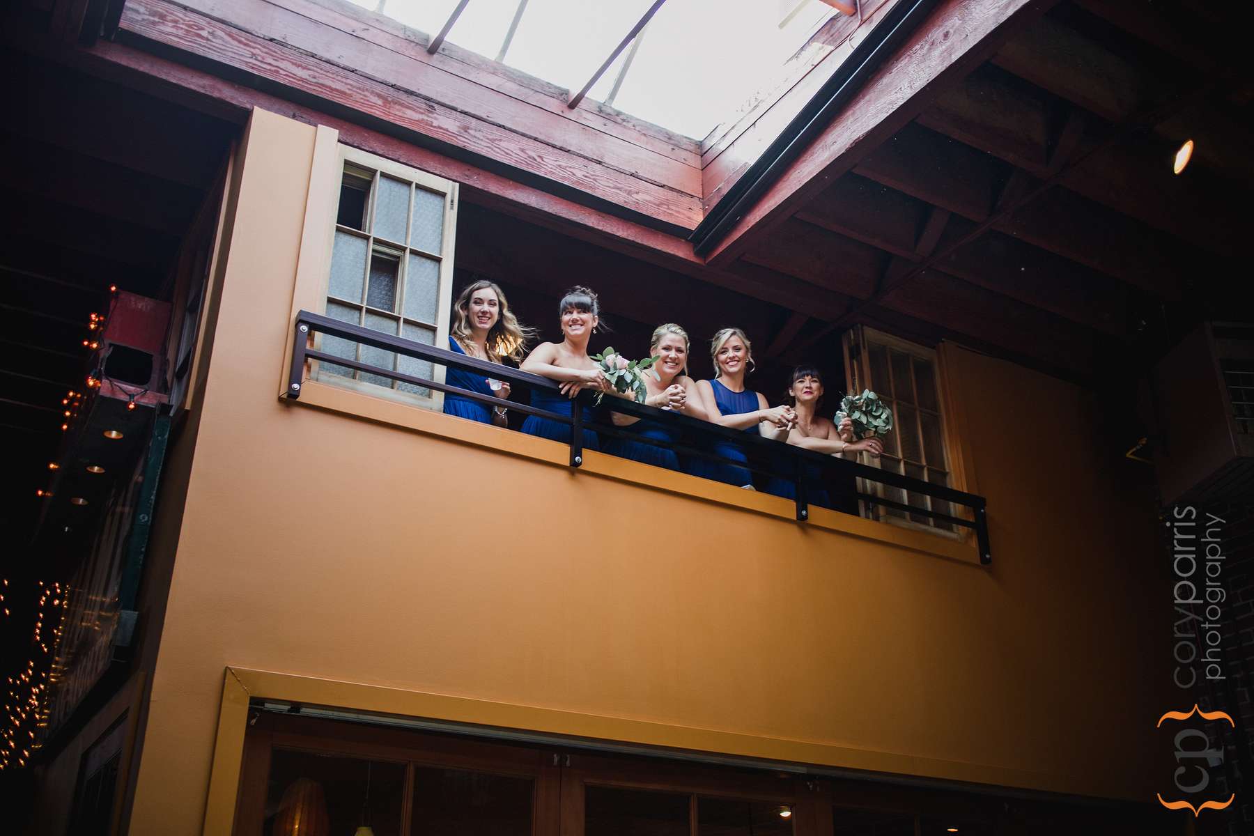  Bridesmaids looking down from the balcony. Photo by Alyssa Parris 