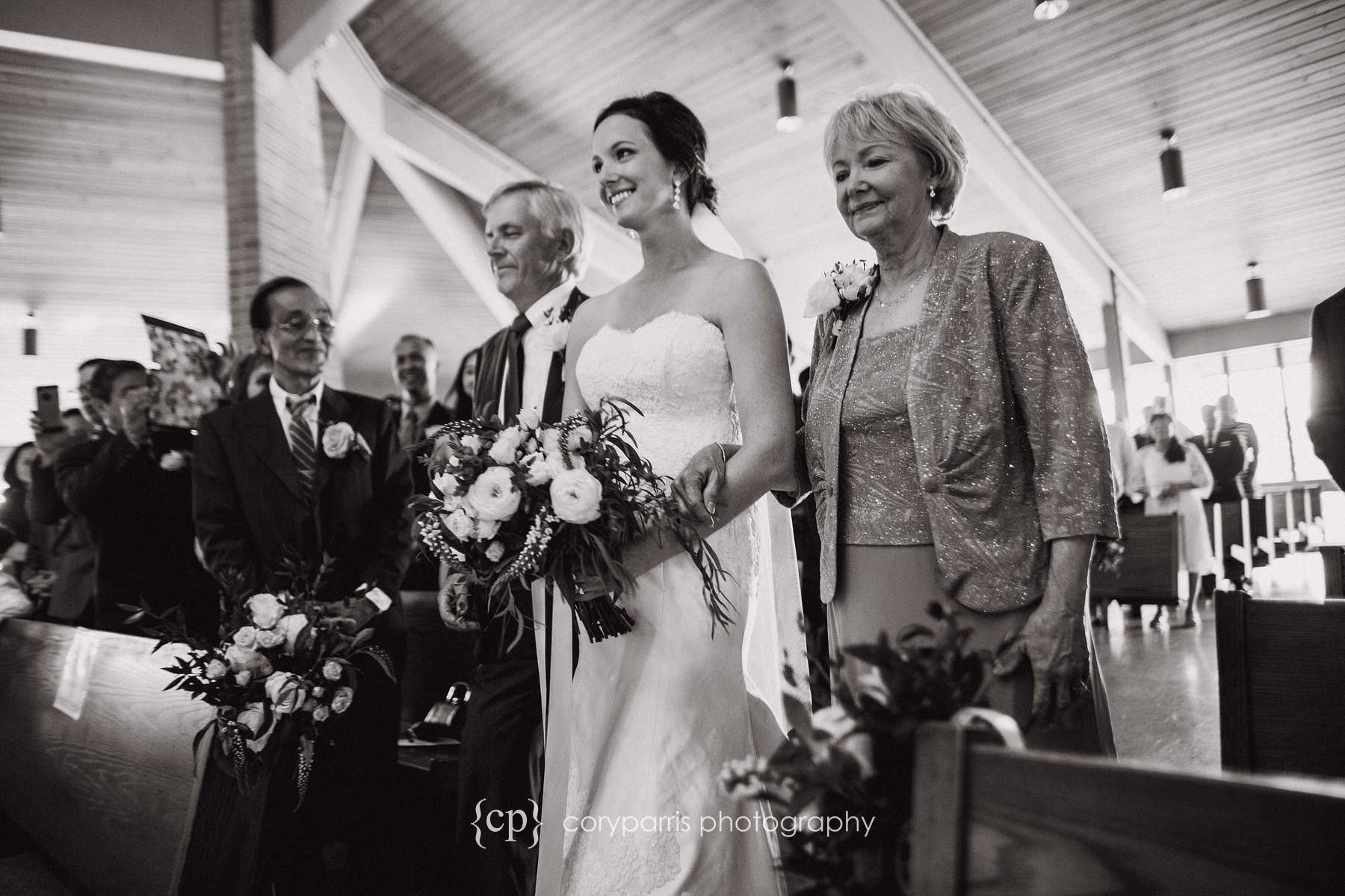 Angie walking down the aisle with her parents before the wedding.