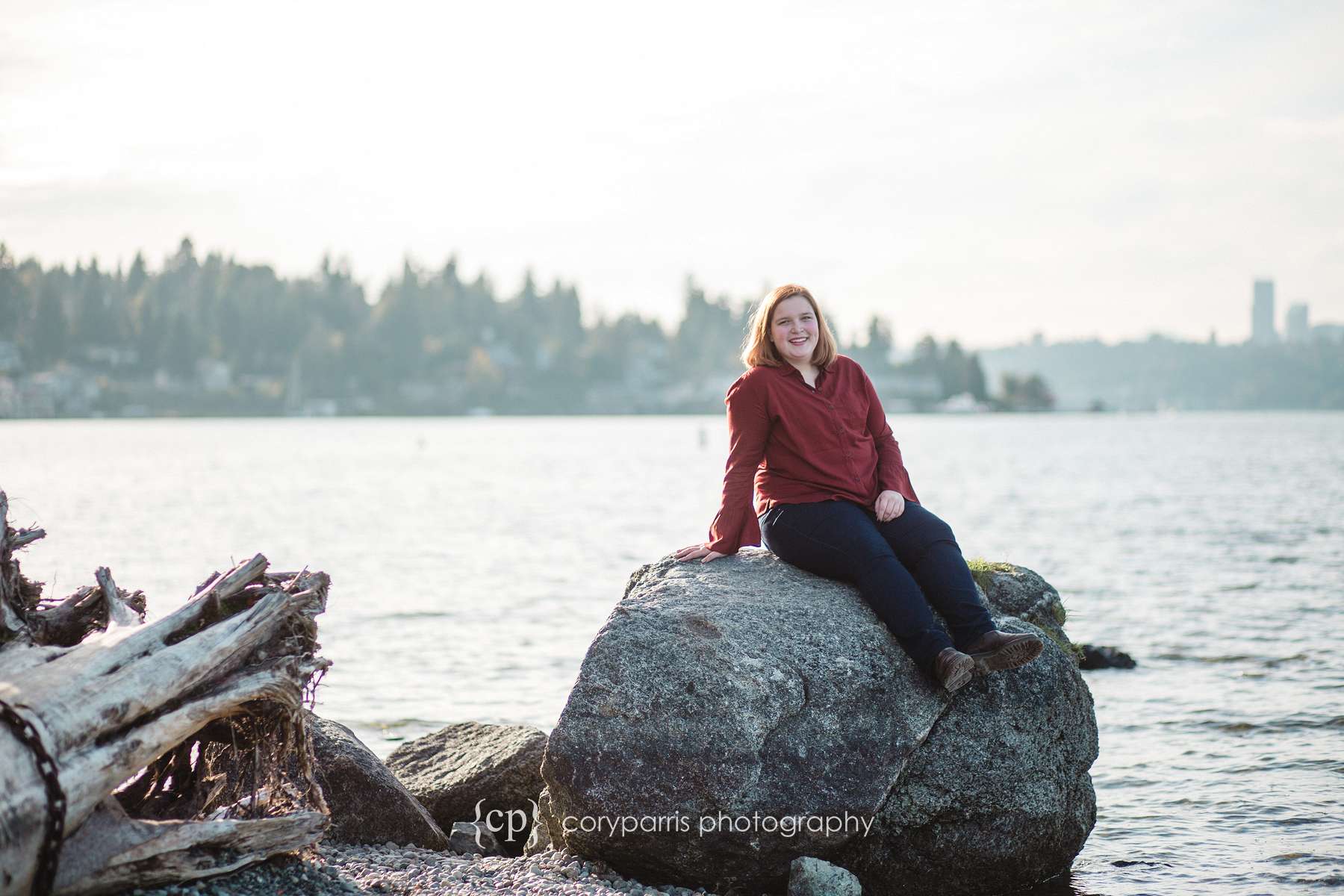  Senior portrait on the beach with Seattle just barely visible in the background 
