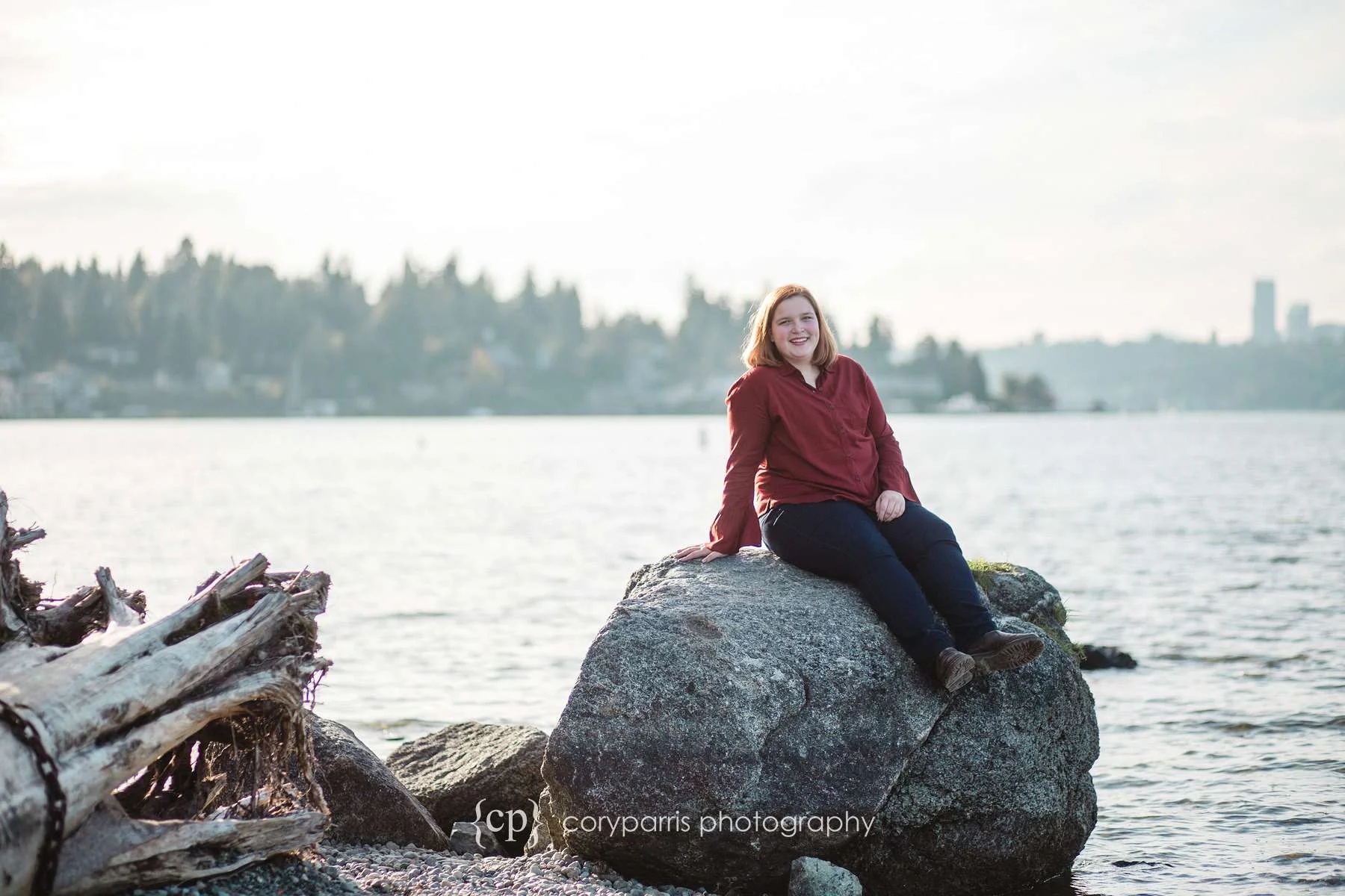 Senior portrait on the beach with Seattle just barely visible in the background