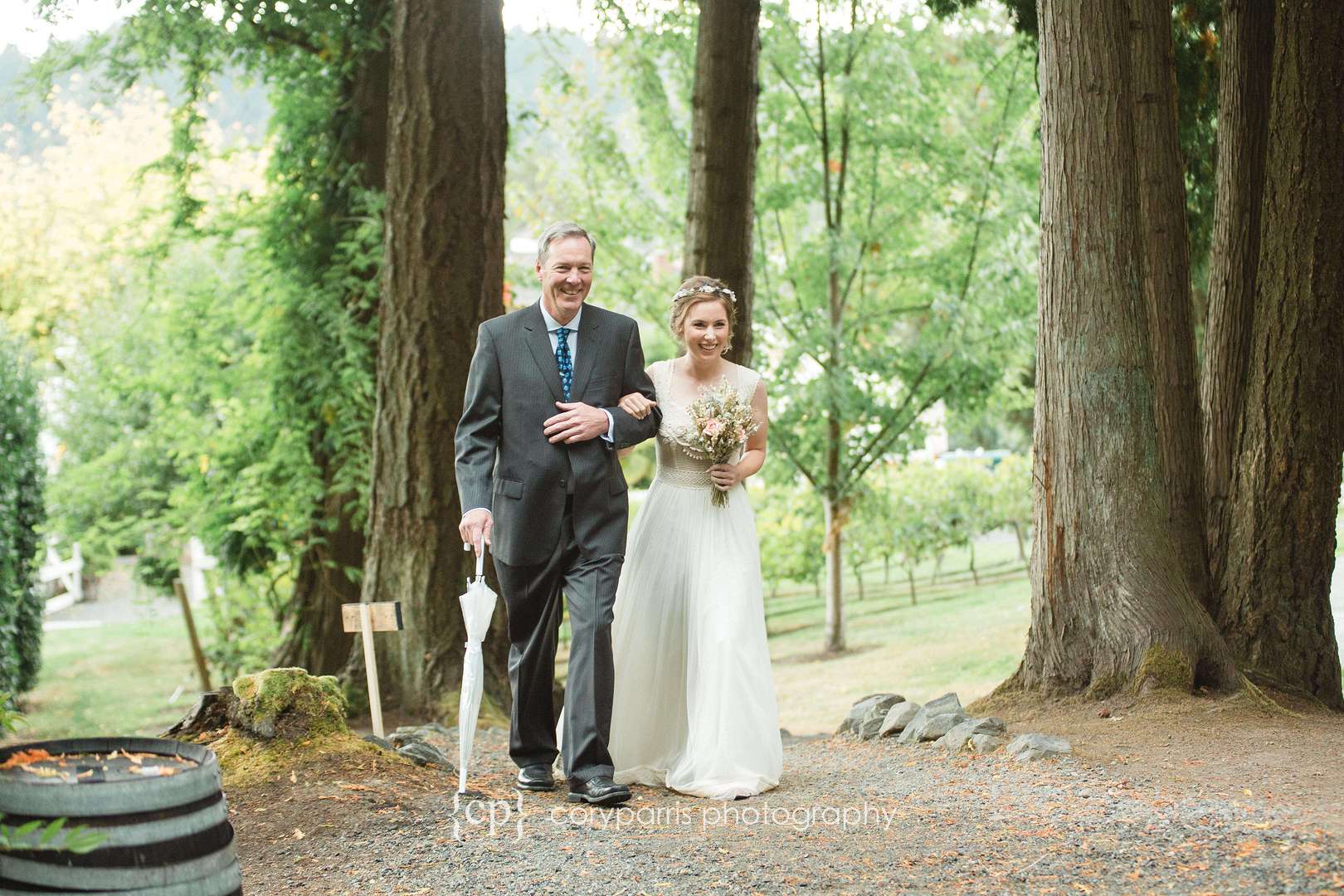 Bride walking with her dad through the trees