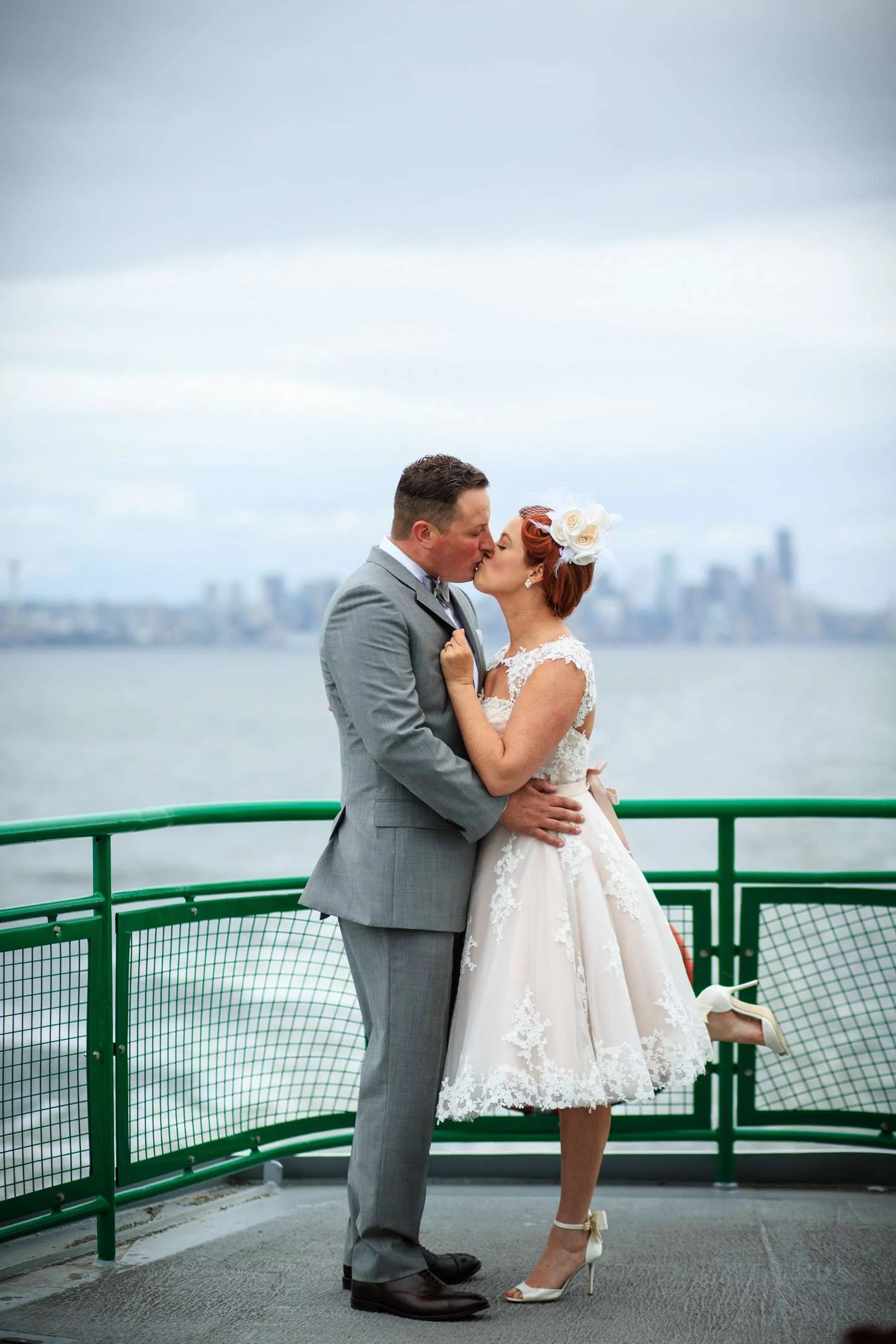Wedding Couple kissing on Ferry with Seattle in background photographer short pink wedding dress
