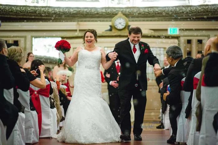 Celebrating the wedding as they walk back down the aisle in a cloud of bubbles.