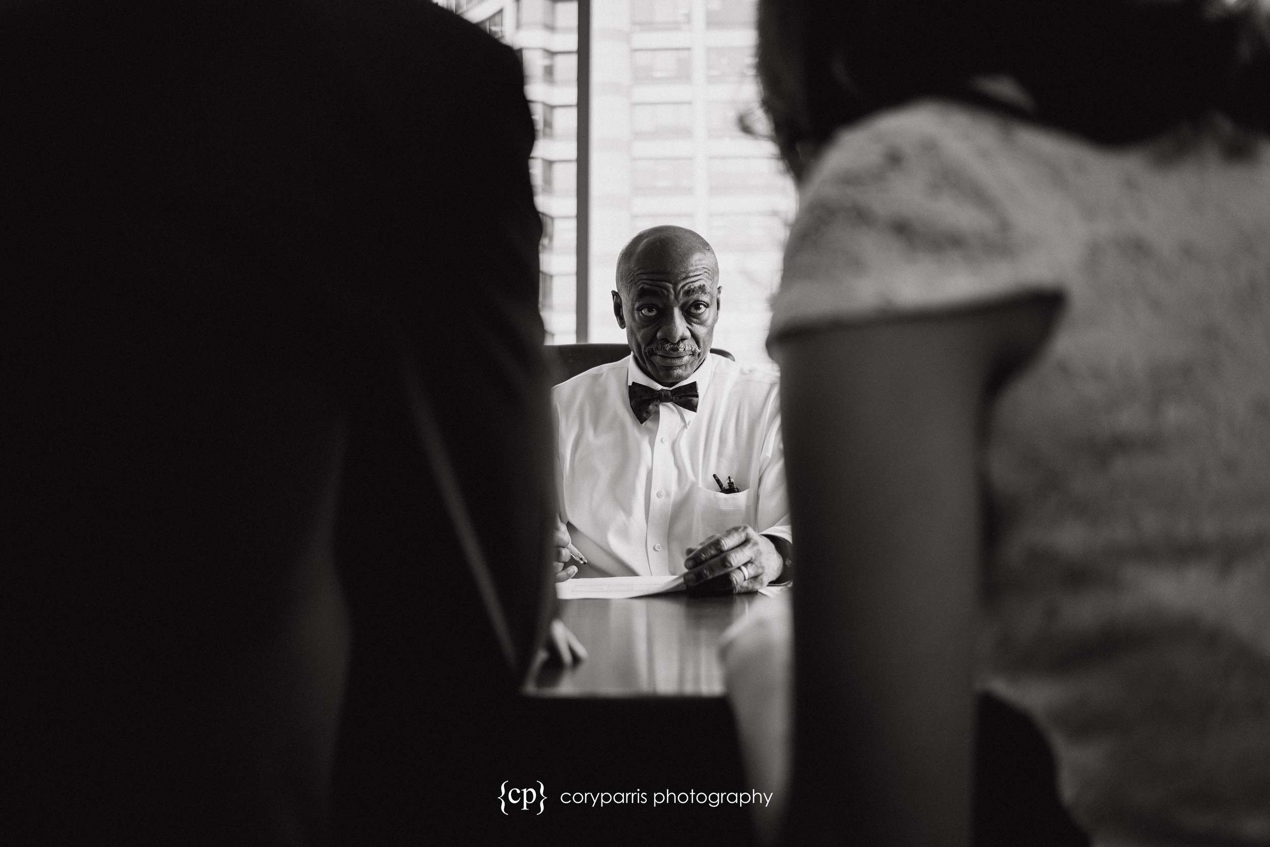 Judge looking at the couple as they fill out paperwork at the Seattle Courthouse