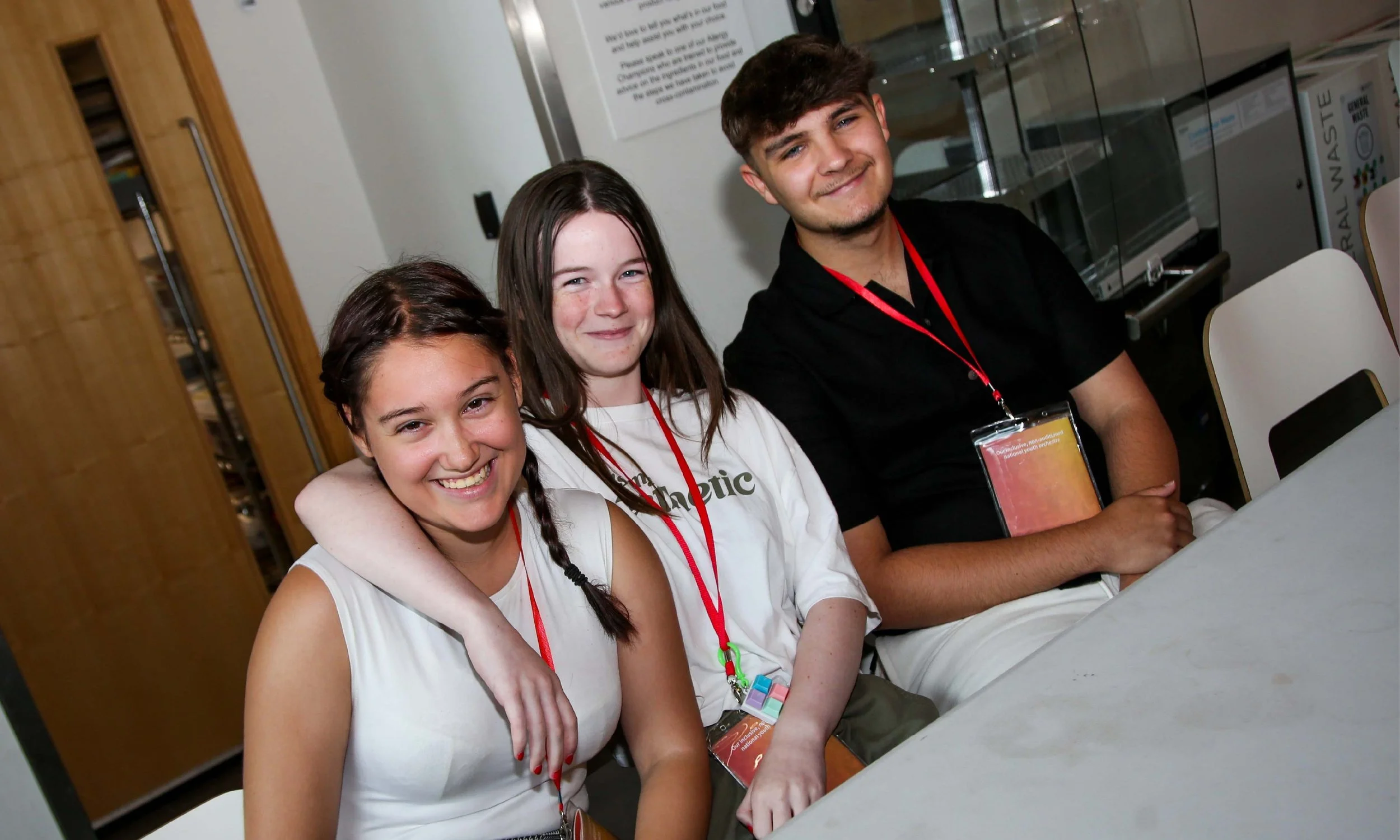 Three National Orchestra for All members sat at a table and smiling together.