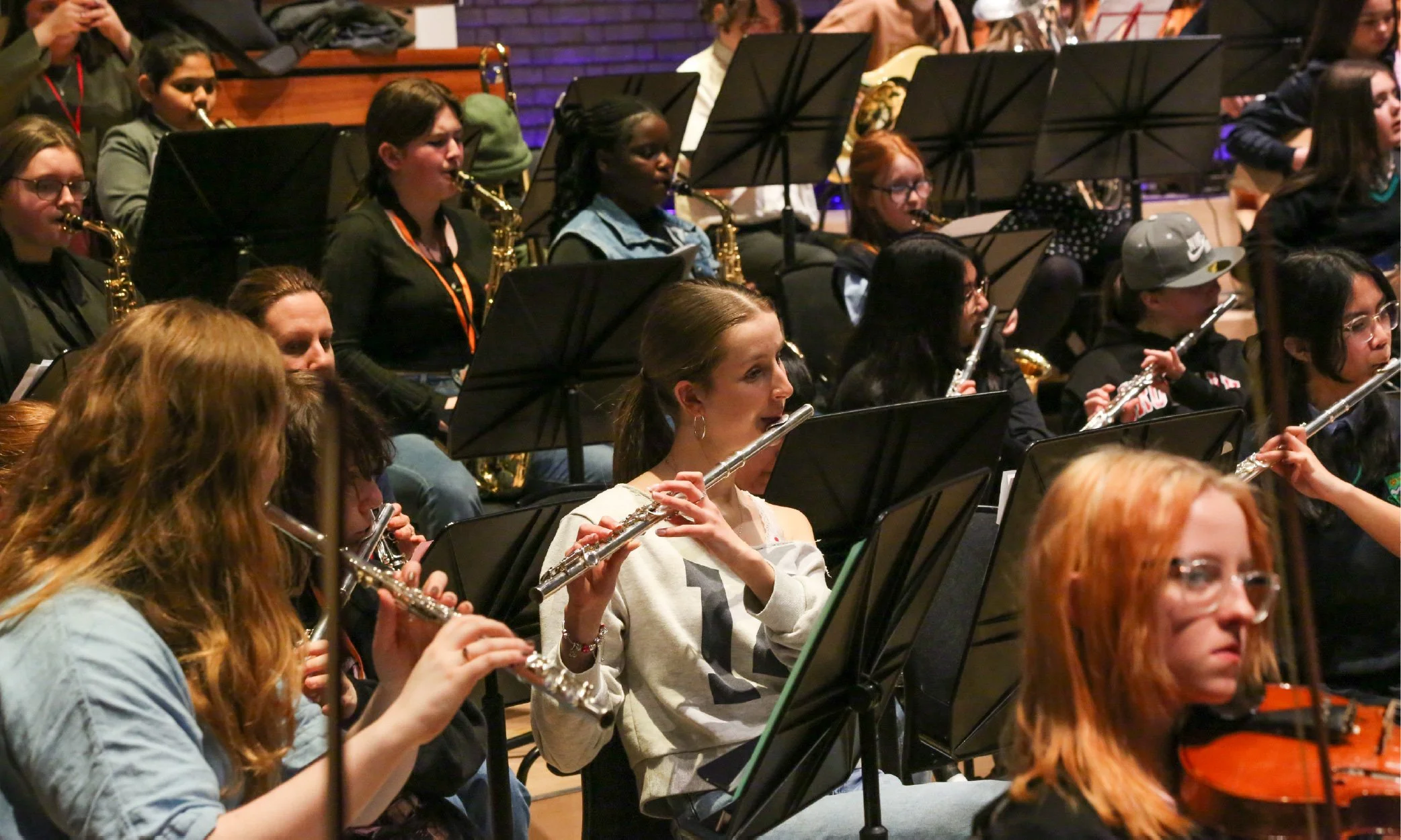 A Modulo woodwind section with a person playing the flute in a dray t-shirt in the middle.