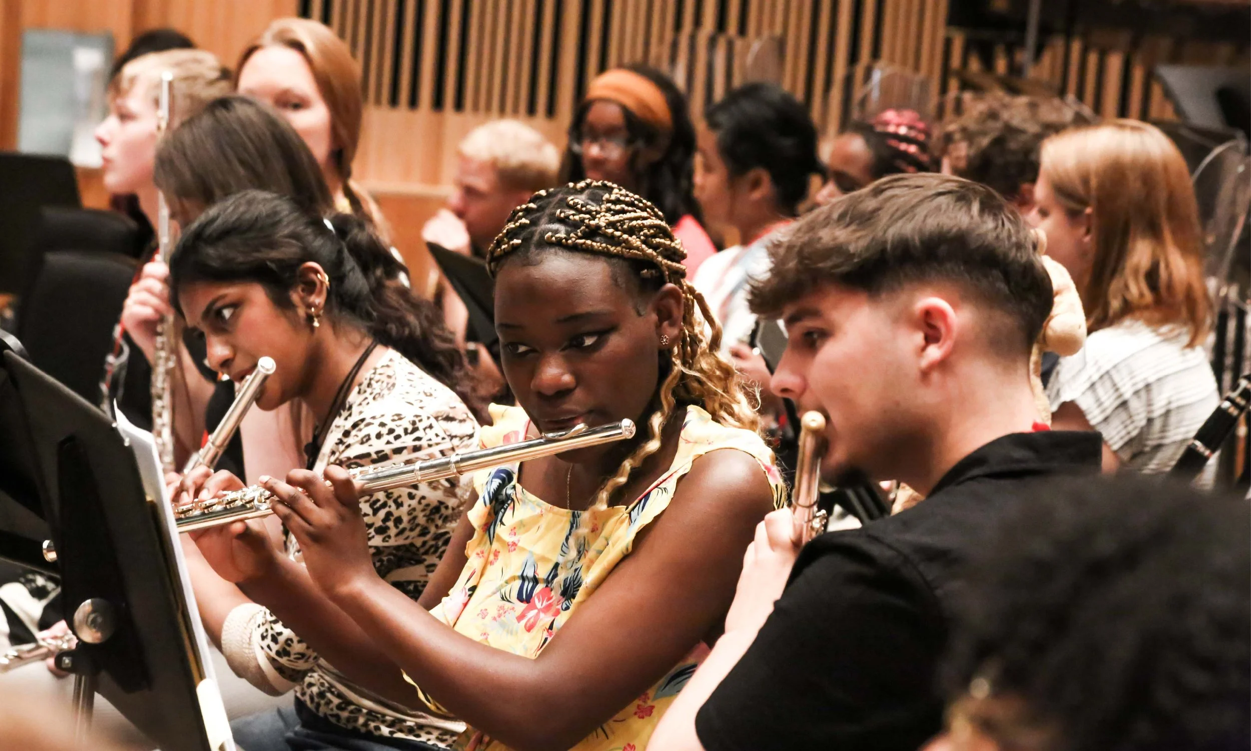 Three members of the National Orchestra for All flute section during a rehearsal.