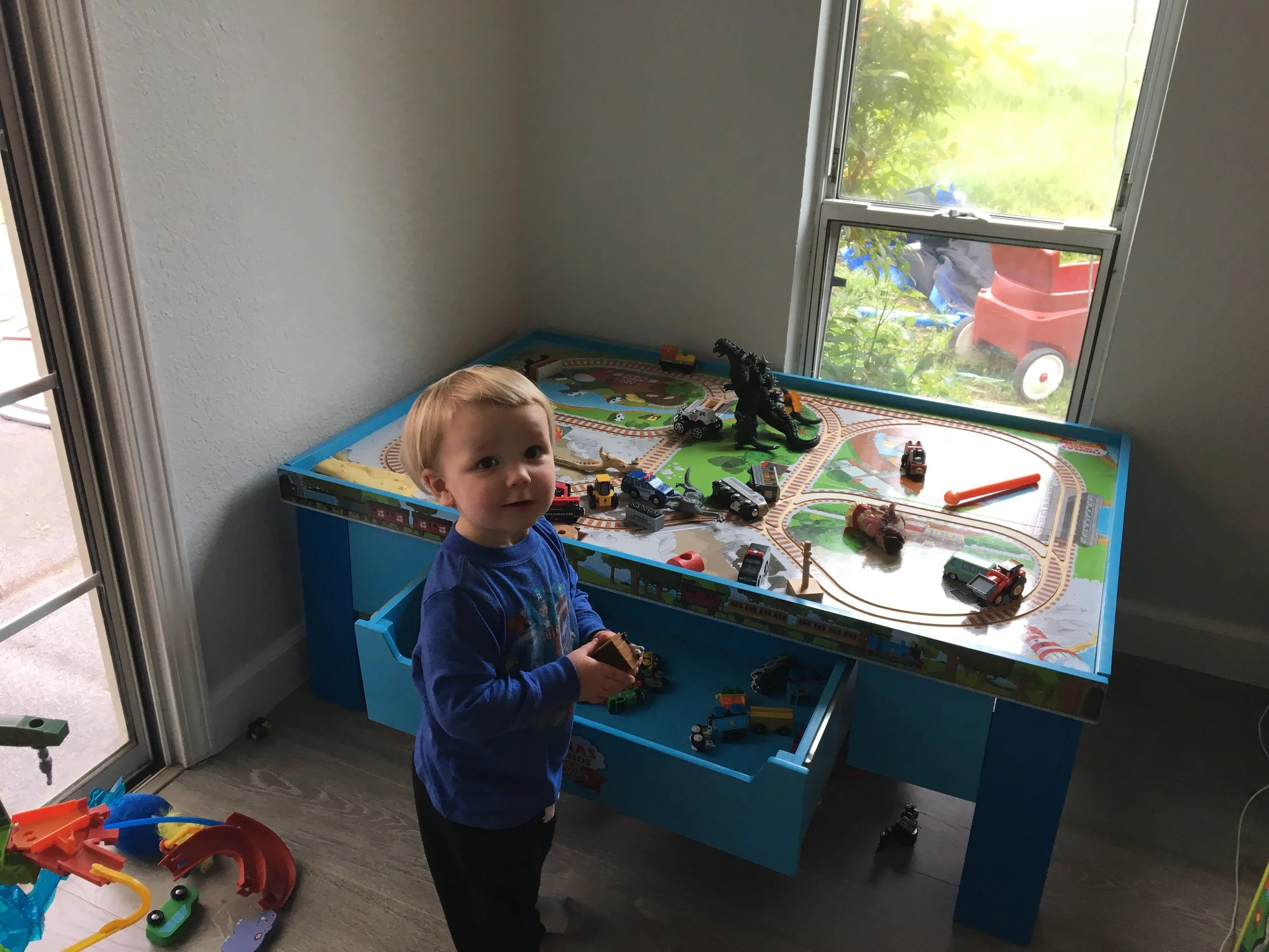 Living his best toddler life -- train table fun at a friend's house