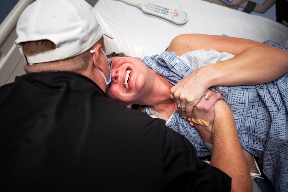 mother grips husbands hand during labor at Dallas hospital