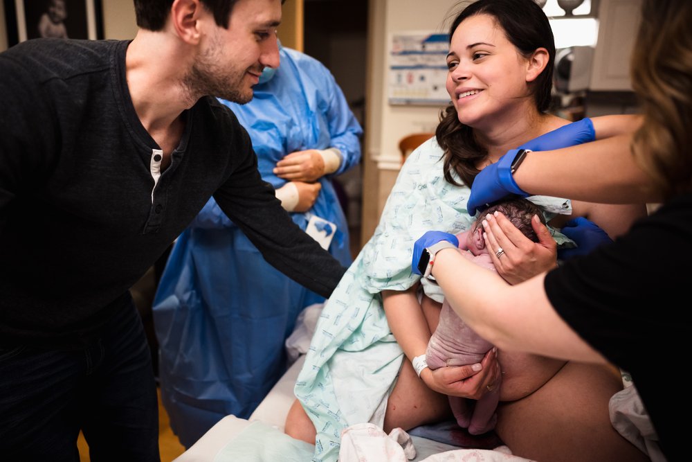 mother smiles at husband just after giving birth at Dallas hospital