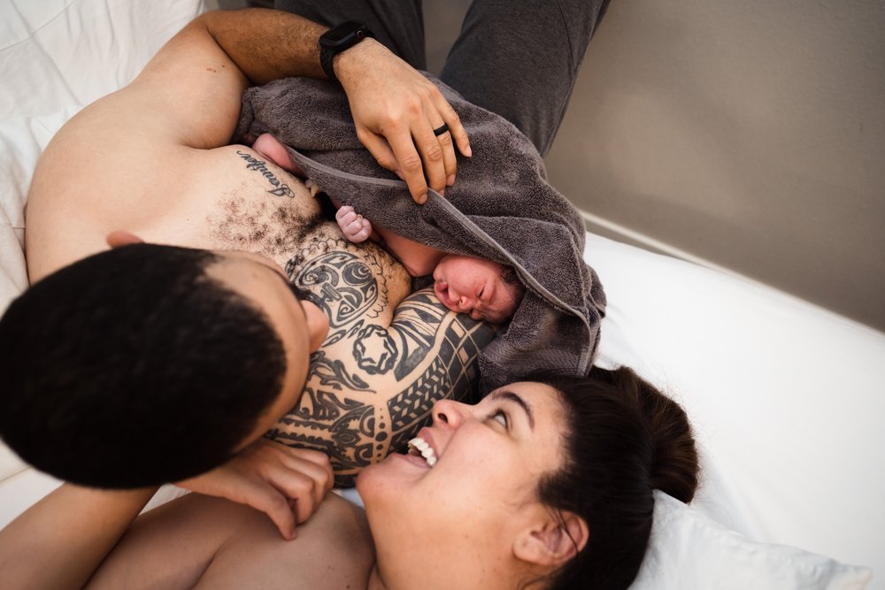 couple smiles at newborn after Dallas home birth
