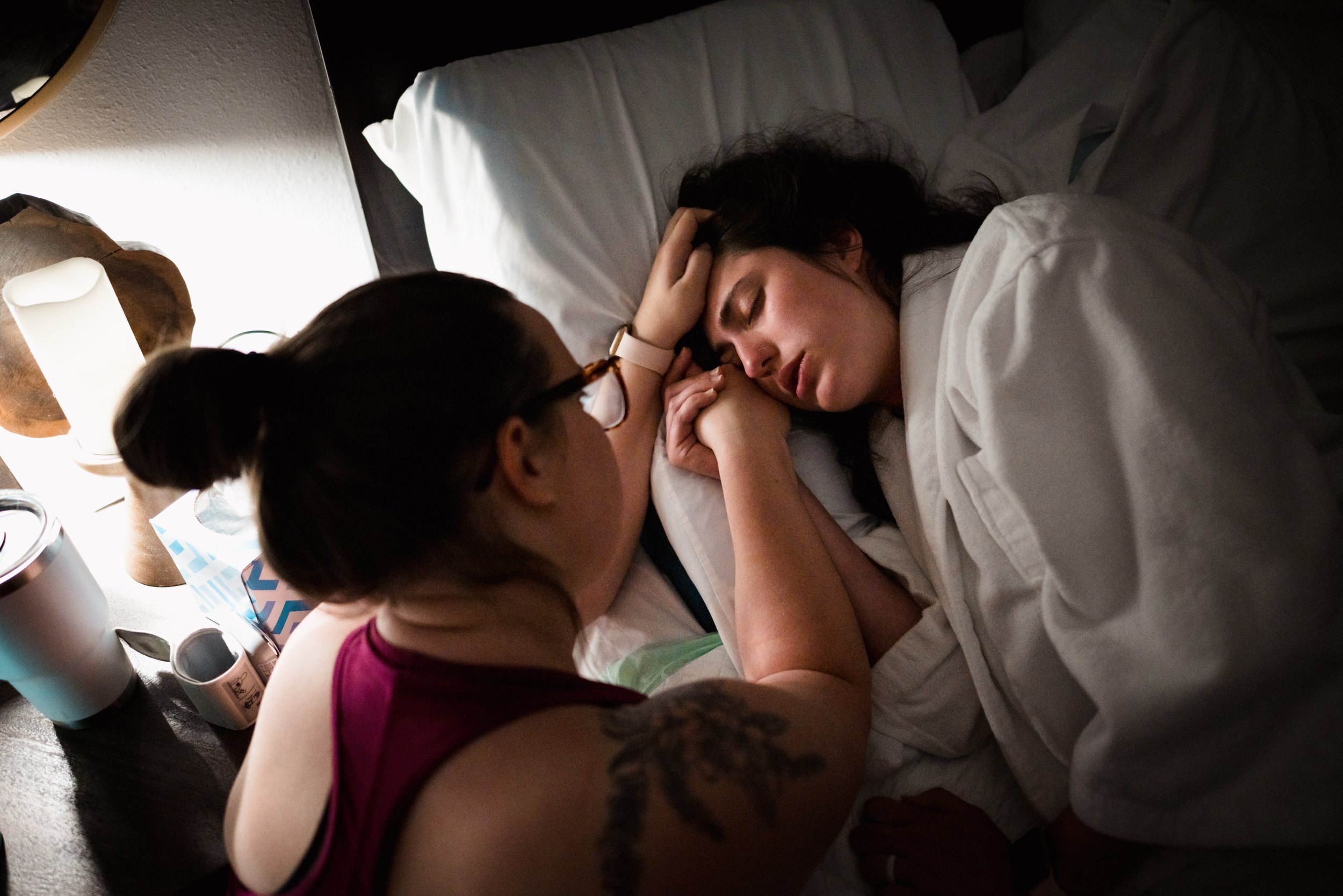 doula comforts mother during labor at home in bed