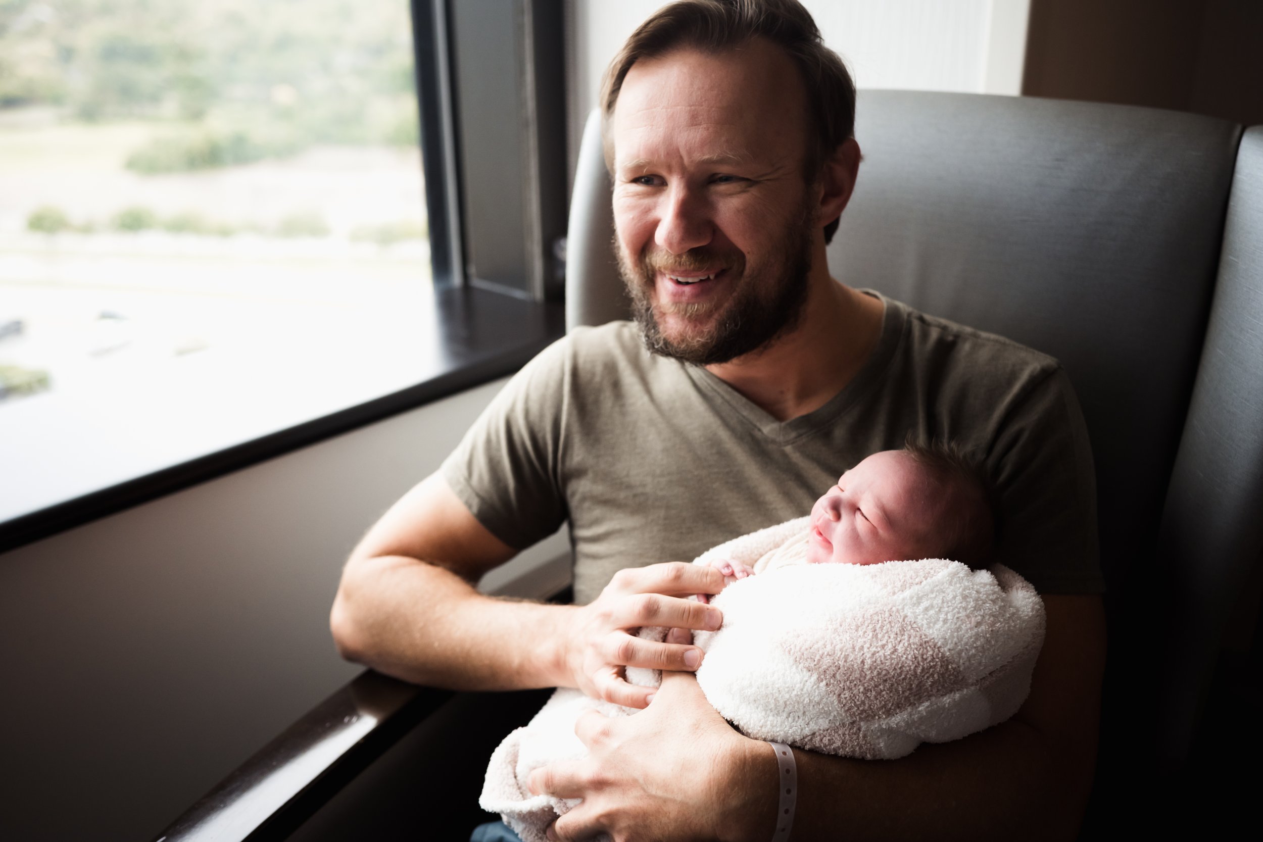 man holds newborn after baby is born 