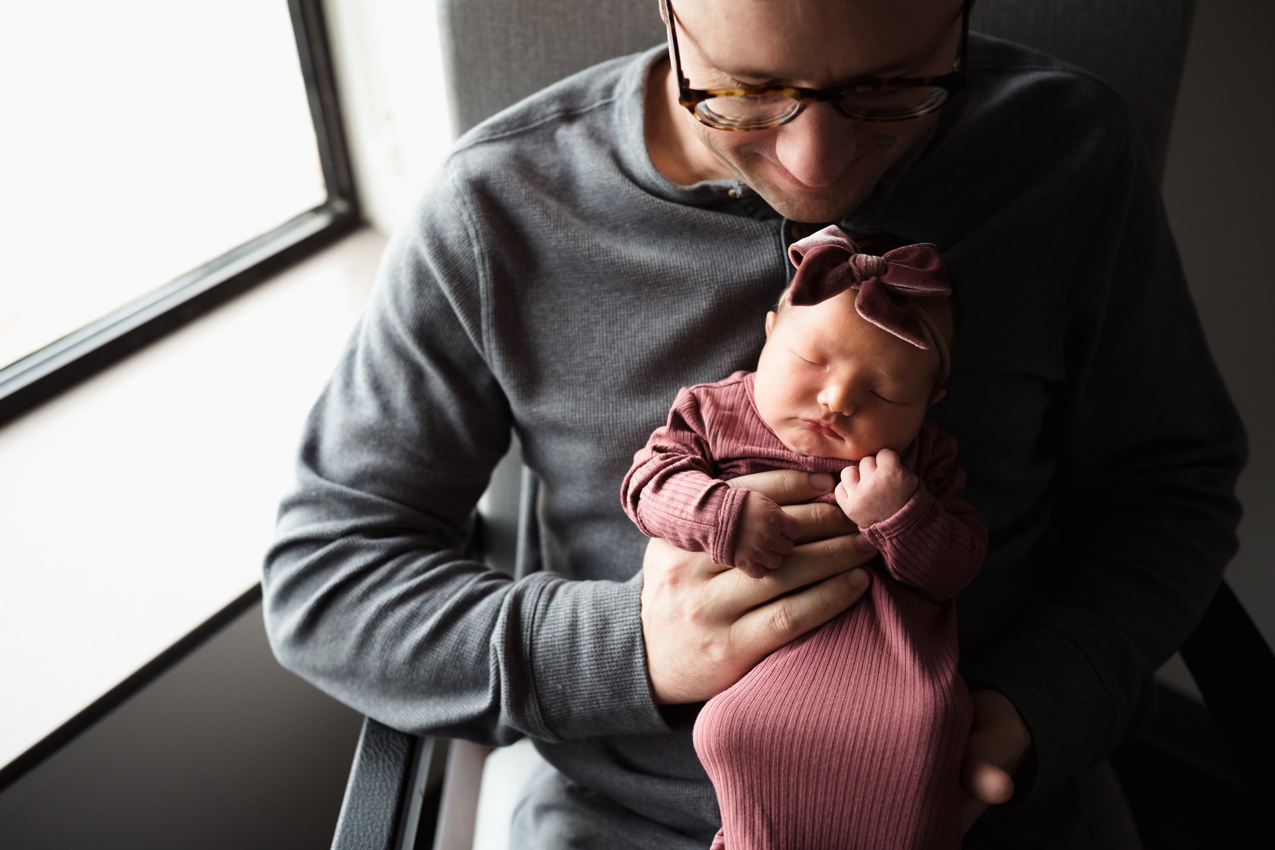 Dad holding newborn daughter at hospital window |Kathryn J birth Stories | Fresh 48 guide