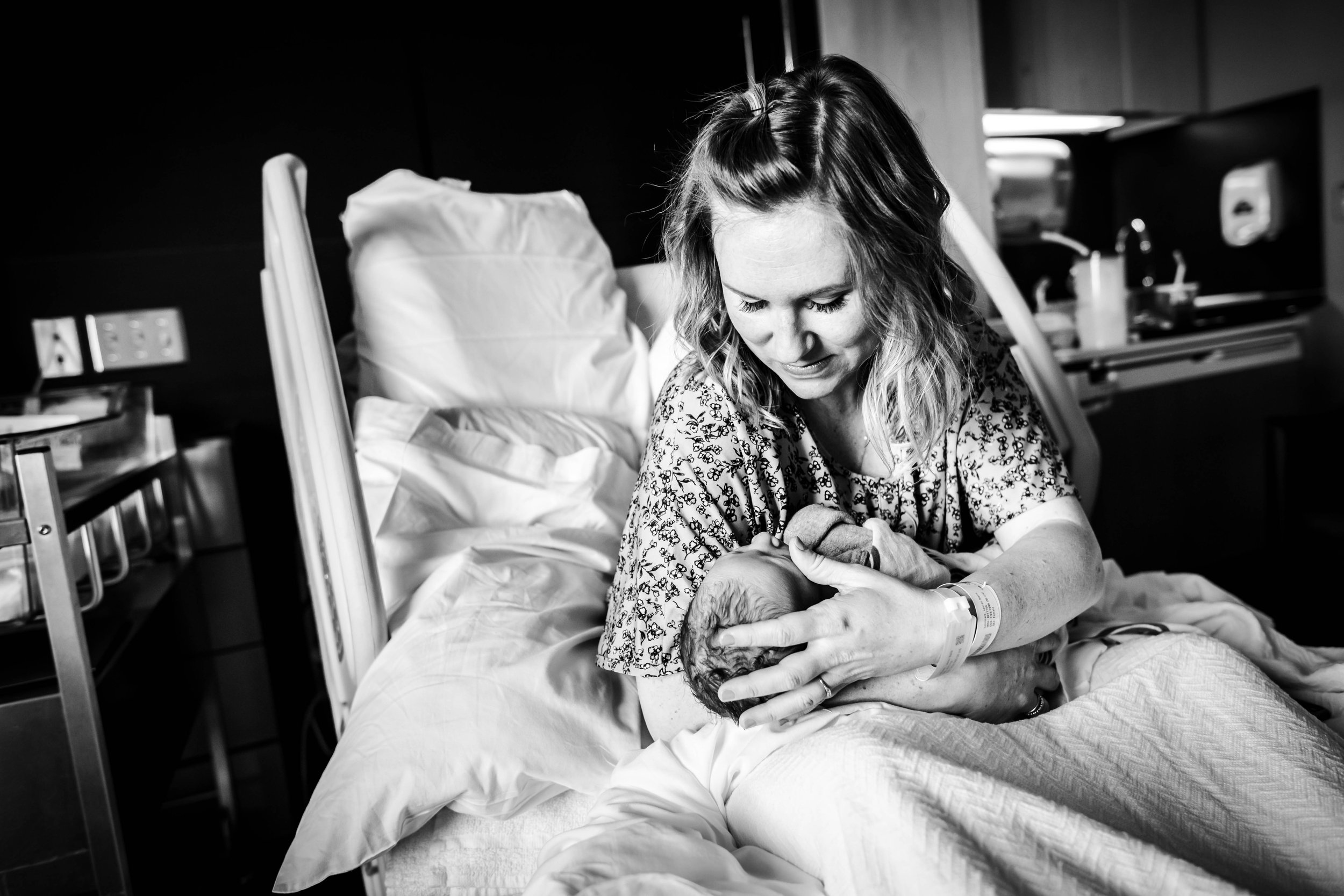 mother holds newborn in hospital bed | Kathryn J birth Stories | Fresh 48 guide | Dallas birth photographer