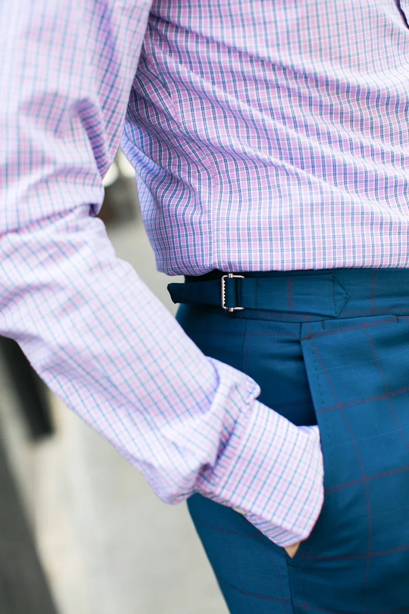 I absolutely love the look of side fasteners on suit trousers. Side fasteners replace belt-loops which gives the waistband a very clean and dressy look. And speaking of waistbands, I never wear a belt with my suit trousers. I prefer the clean look going beltless whether you have belt-loops or not. For extra style points, wear braces with your suit for a refined look.