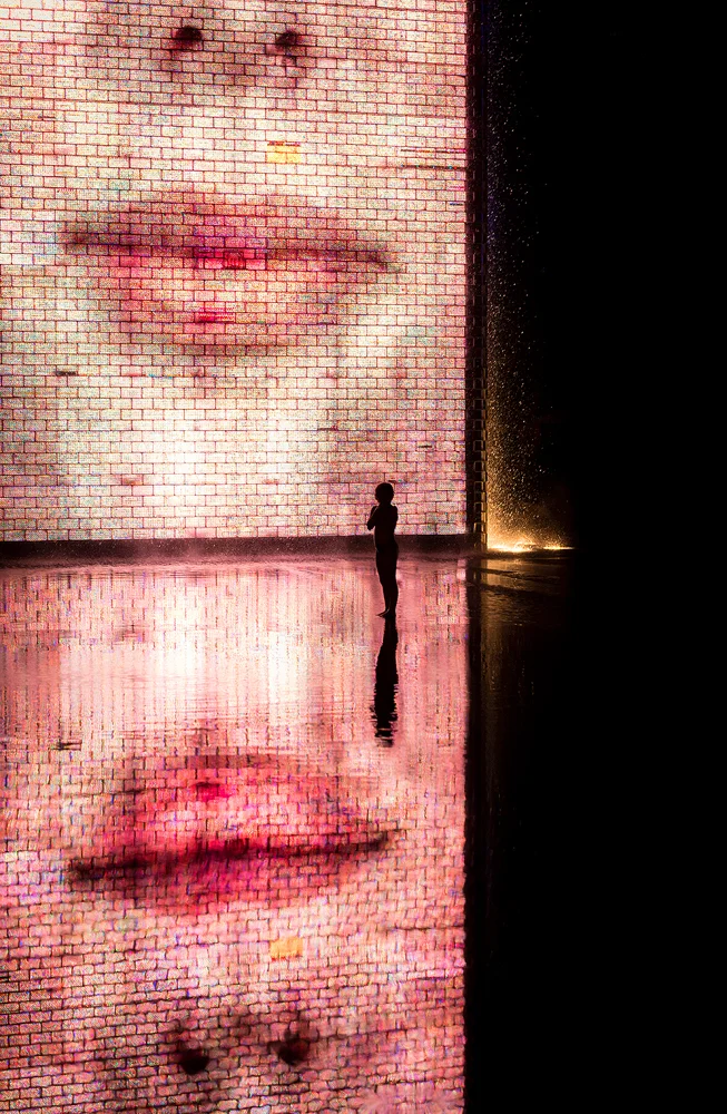 There is an interactive work of public art called Crown Fountain at the Millennium Park in Chicago, Illinois. In the fountain, a granite reflecting pool is placed between two glass brick towers, making the artwork look especially impressive in the dark. Besides being a piece of art, the fountain appeared to be popular among children as a playground. I waited a while just looking at their play and then, a little girl stayed behind the rest of the group of children in the pool, forming a single silhouette figure in front of the illuminated glass bricks. For me, this was the picture I was looking for here. On the technical side, there is nothing special in the image; this is a single exposure, post-processed in Lightroom and Photoshop.