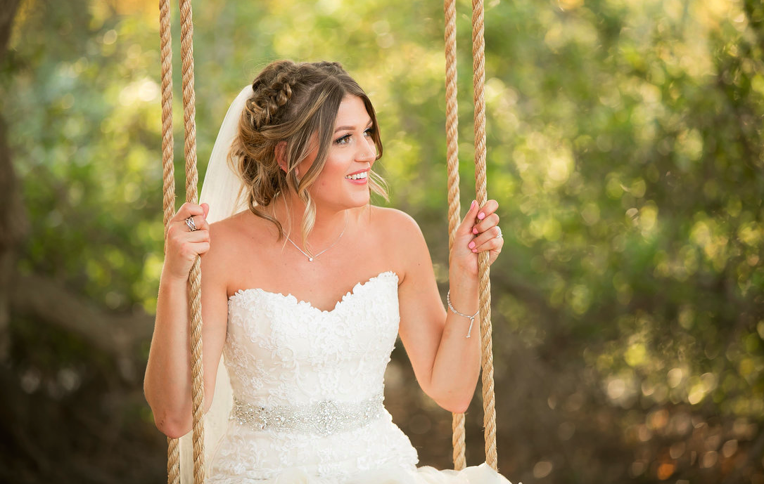 Wedding Hairstyle with Braided updo, Veil and Natural Makeup. Photos taken outside on Swing. Bridal hair and makeup by Vanity Belle in Orange County (Costa Mesa) and San Diego (La Jolla)