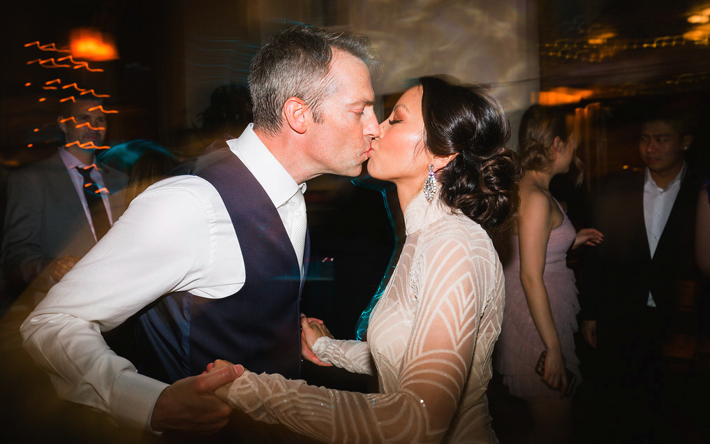 Wedding reception photos with bride and husband kissing. Bridal Hair and Makeup by Vanity Belle in Orange County (Costa Mesa) and San Diego (La Jolla)