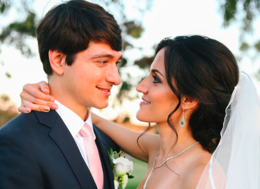 Brunette Bride with Updo Hairstyle and Veil Looking into Husband's Eyes in Outdoor Wedding Photos. Bridal hair and makeup by Vanity Belle in Orange County (Costa Mesa) and San Diego (La Jolla)