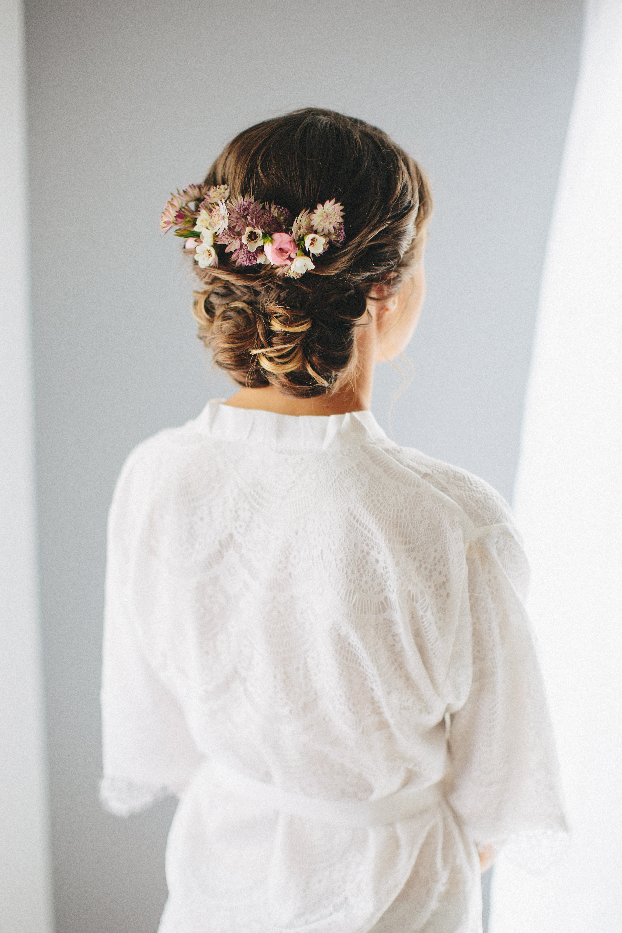 Wedding Updo from Behind with Flowers and Bride Wearing Robe. Bridal hair and makeup by Vanity Belle in Orange County (Costa Mesa) and San Diego (La Jolla)