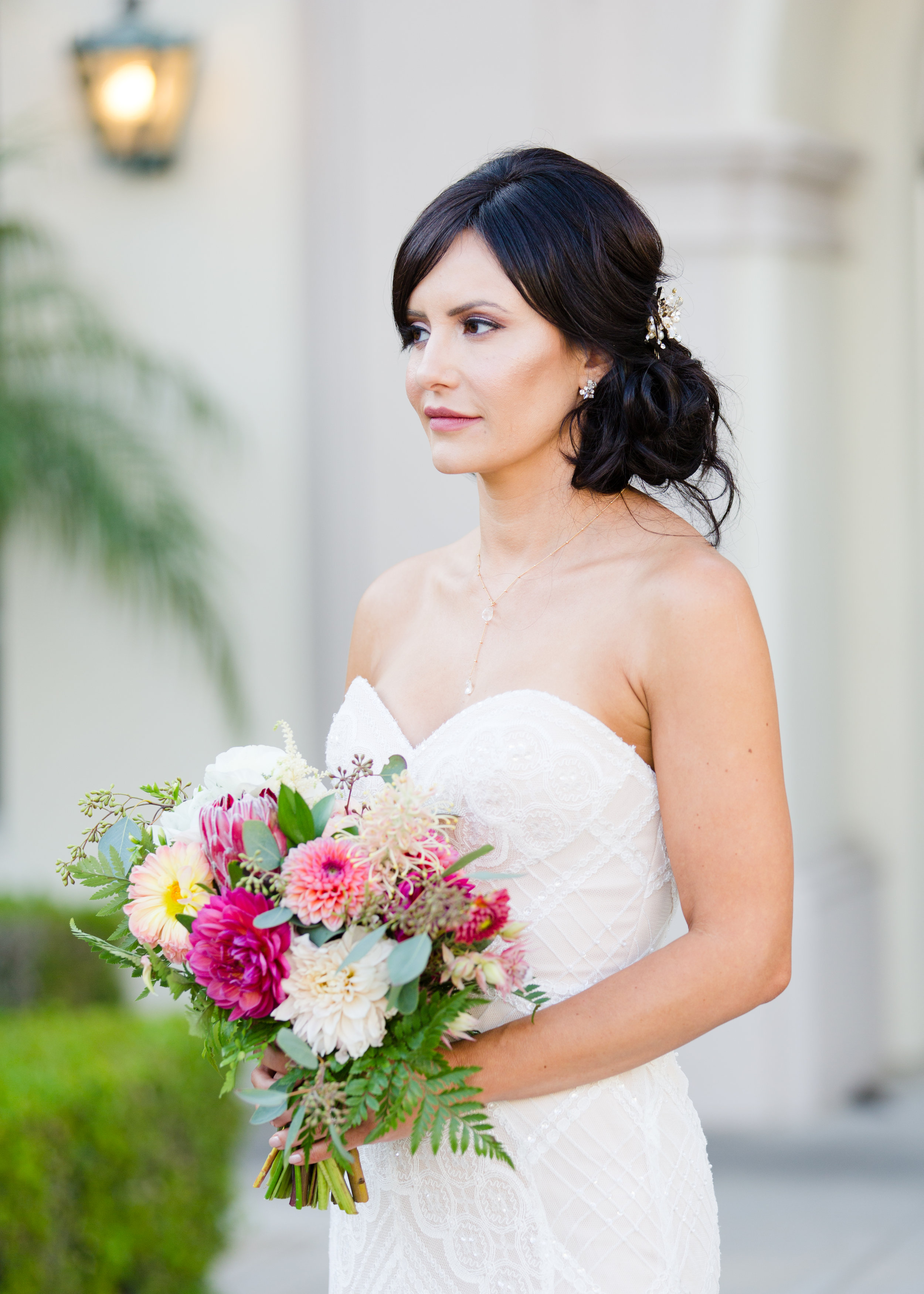Brunette Bride with Updo Hairstyle holding bouquet outside in Wedding Photography. Bridal Hair and Makeup by Vanity Belle in Orange County (Costa Mesa) and San Diego (La Jolla)