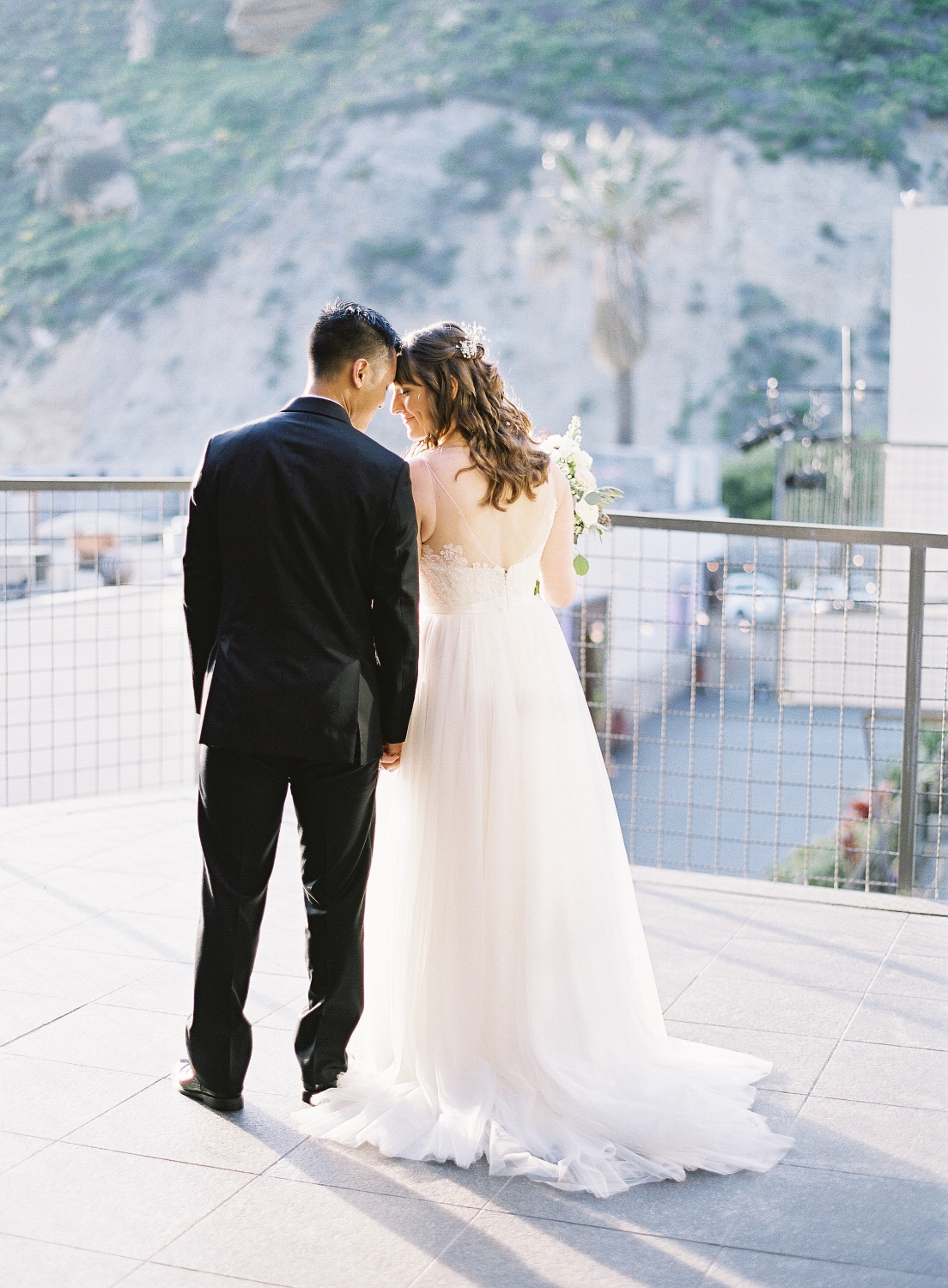 Wedding Photo with Couple from Behind. Bridal Hairstyles and makeup by Vanity Belle in Orange County (Costa Mesa) and San Diego (La Jolla)