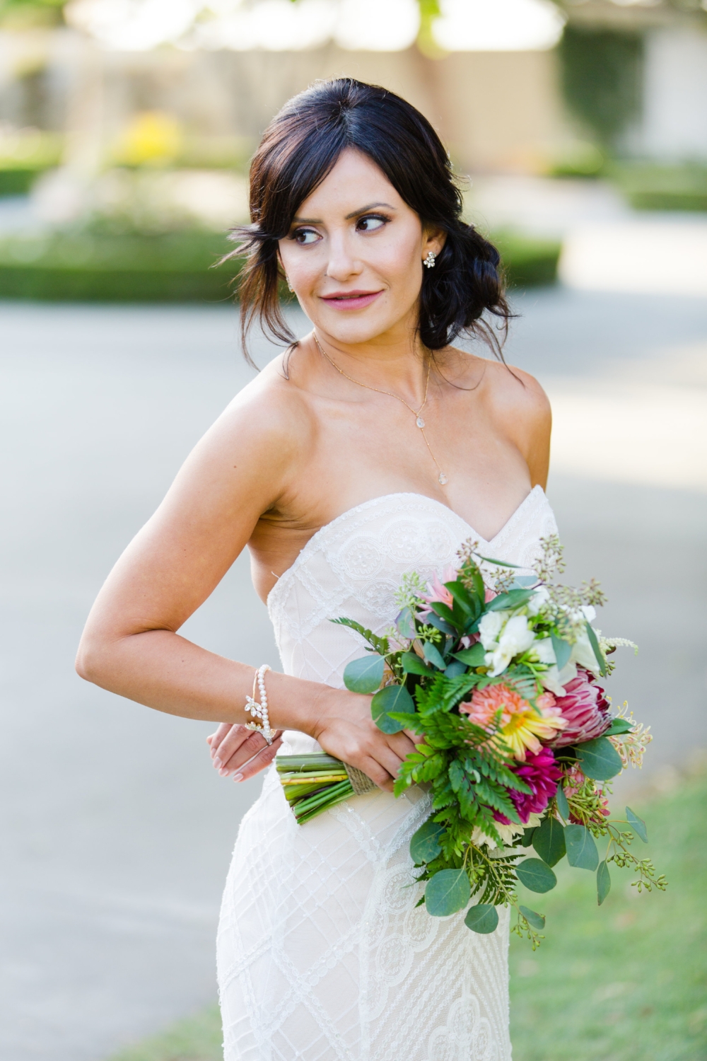 Brunette Bride with Updo holding bouquet outside in Wedding Photography. Bridal Hair and Makeup by Vanity Belle in Orange County (Costa Mesa) and San Diego (La Jolla)