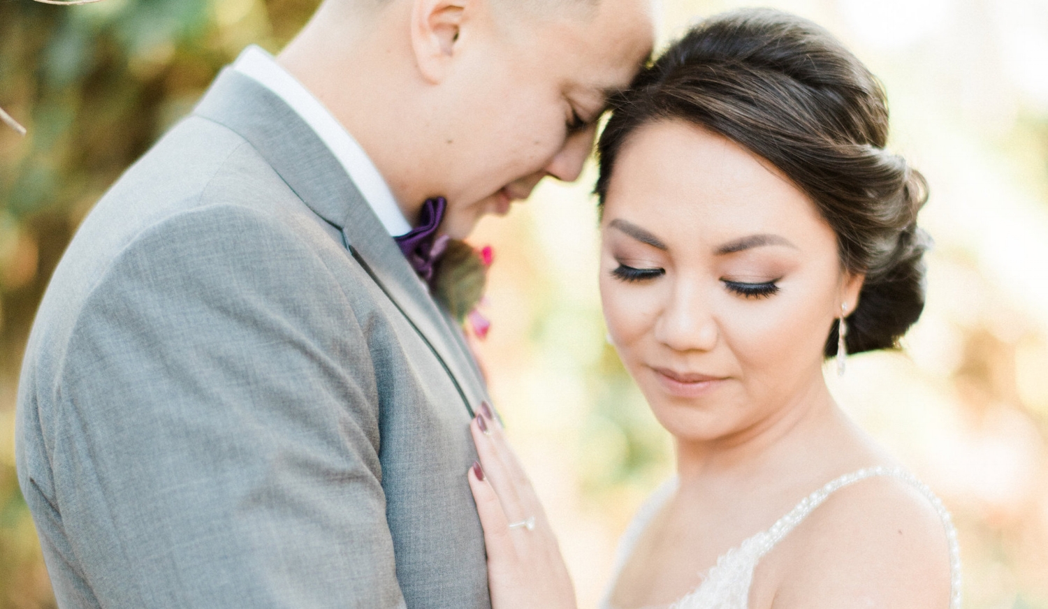 Asian Bride with Simple Makeup and Updo Hairstyle with Husband outside in Wedding Photos. Bridal Hair and Makeup by Vanity Belle in Orange County (Costa Mesa) and San Diego (La Jolla)