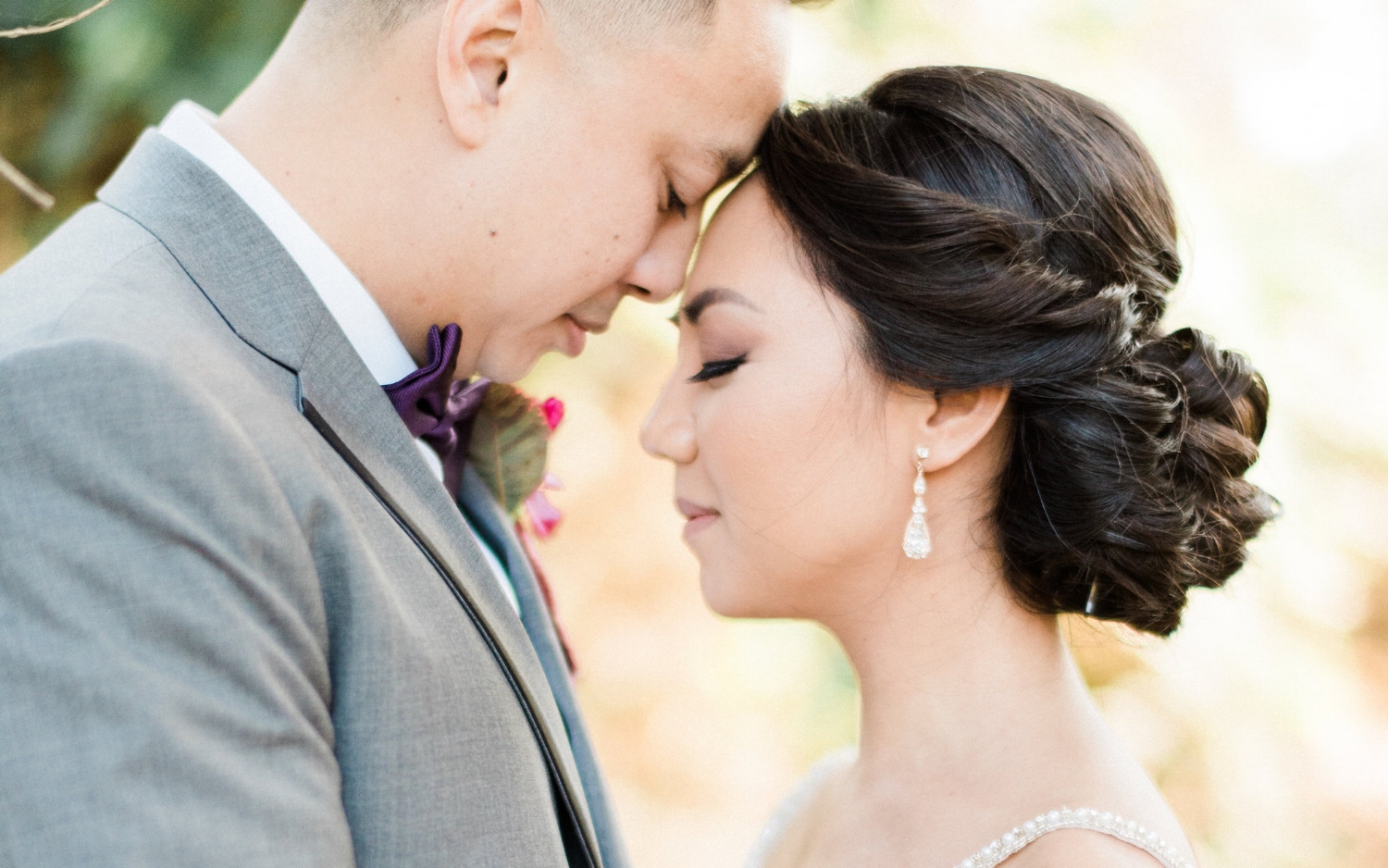 Asian Bride with Simple Makeup and Updo Hairstyle with Husband outside in Wedding Photos. Bridal Hair and Makeup by Vanity Belle in Orange County (Costa Mesa) and San Diego (La Jolla)