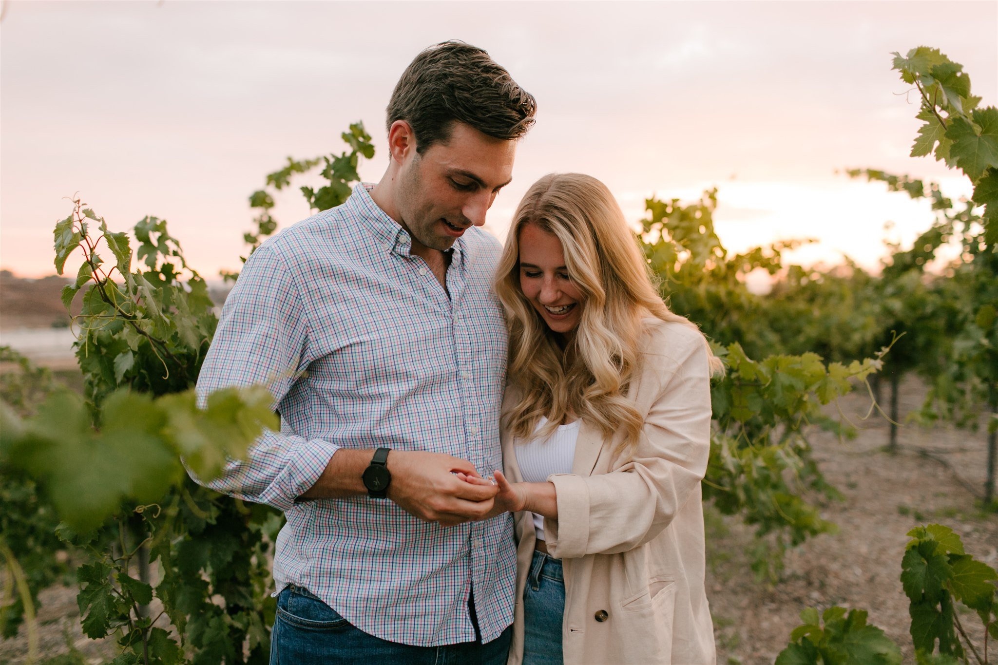 couple viewing engagement ring in vineyard
