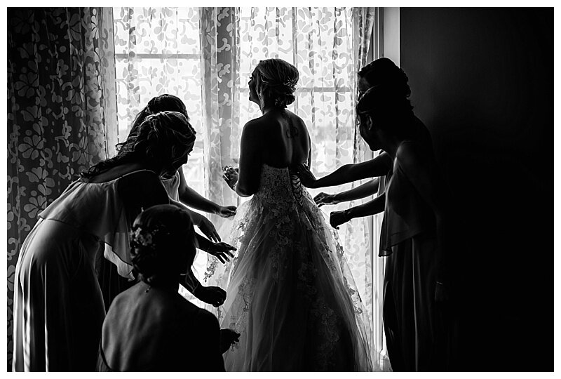 bridesmaids getting bride dressed