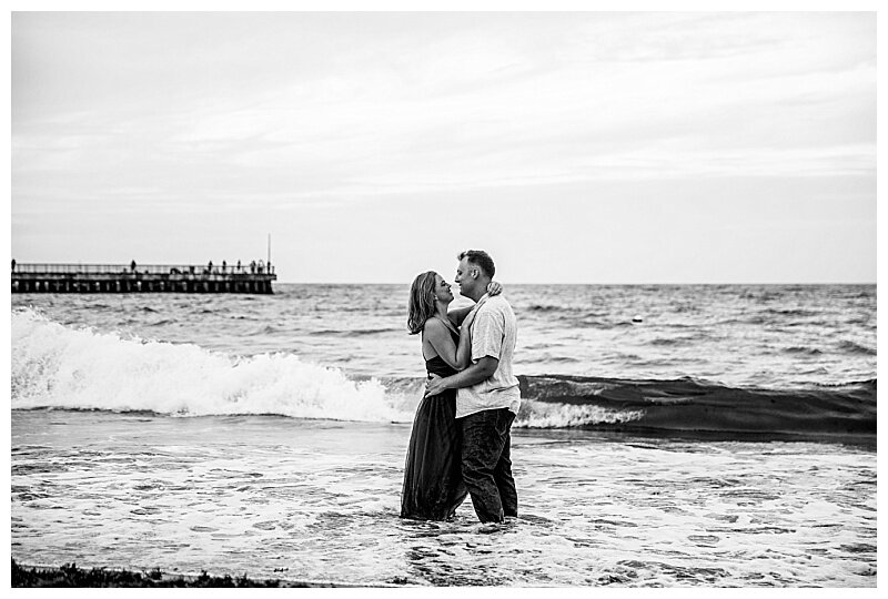 BW image of couple playing in the ocean