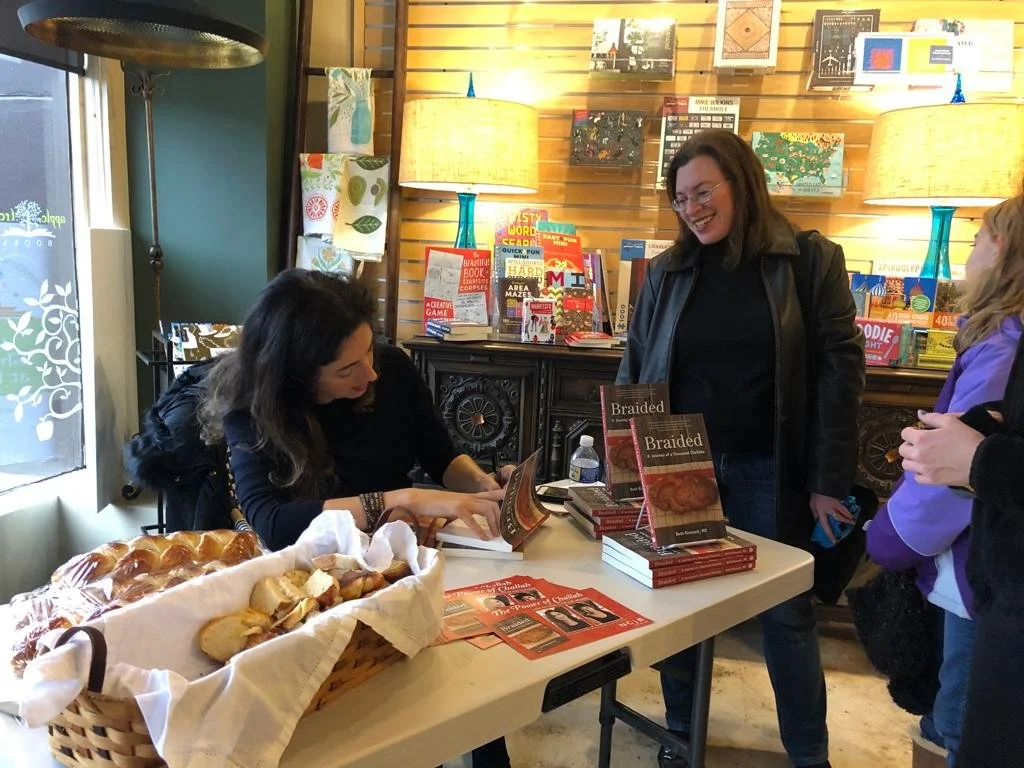 Beth Ricanati MD signing copy of a reader's book