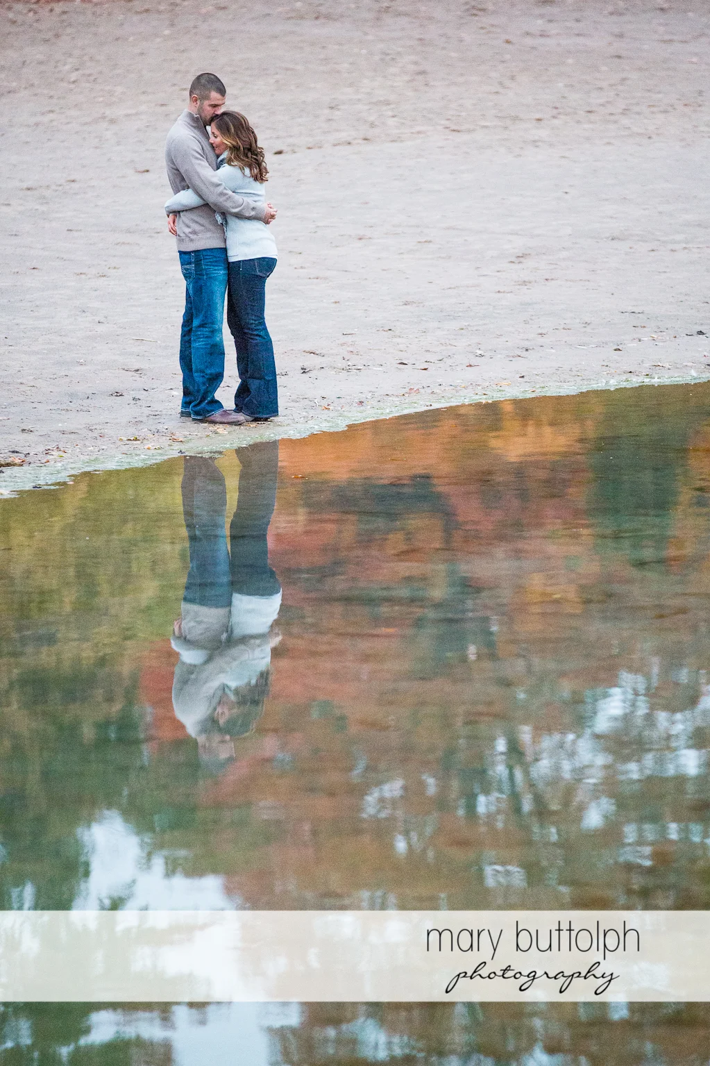 Couple embrace near the lake at Skaneateles Engagement