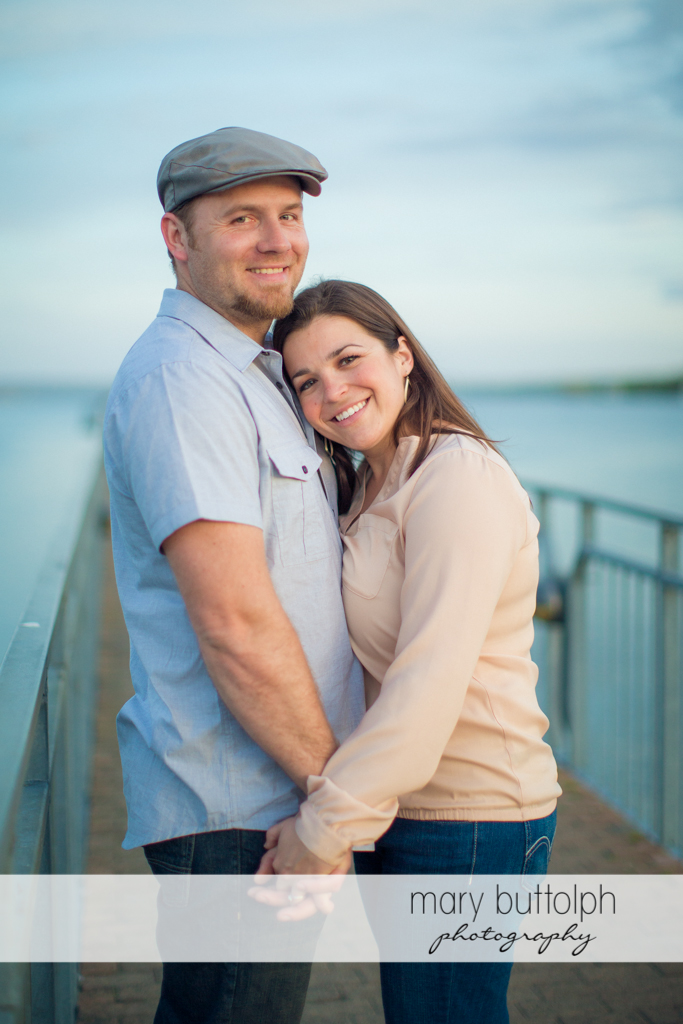 Couple hold hands near the lake at Skaneateles Engagement